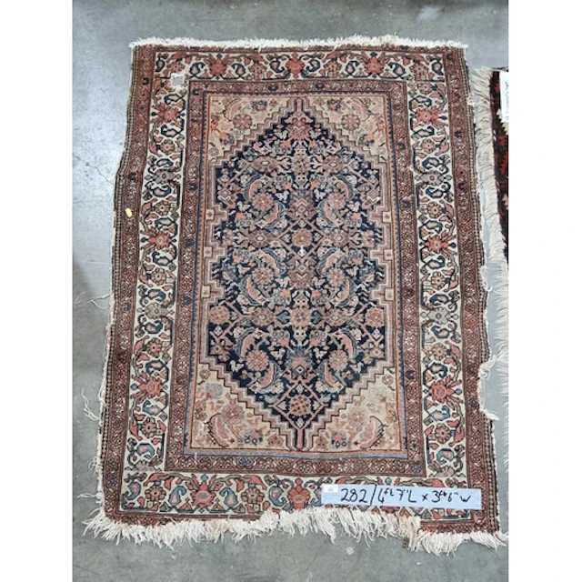 A Persian Rug with floral borders 4ft 7in x 3ft 6in A/F and ...