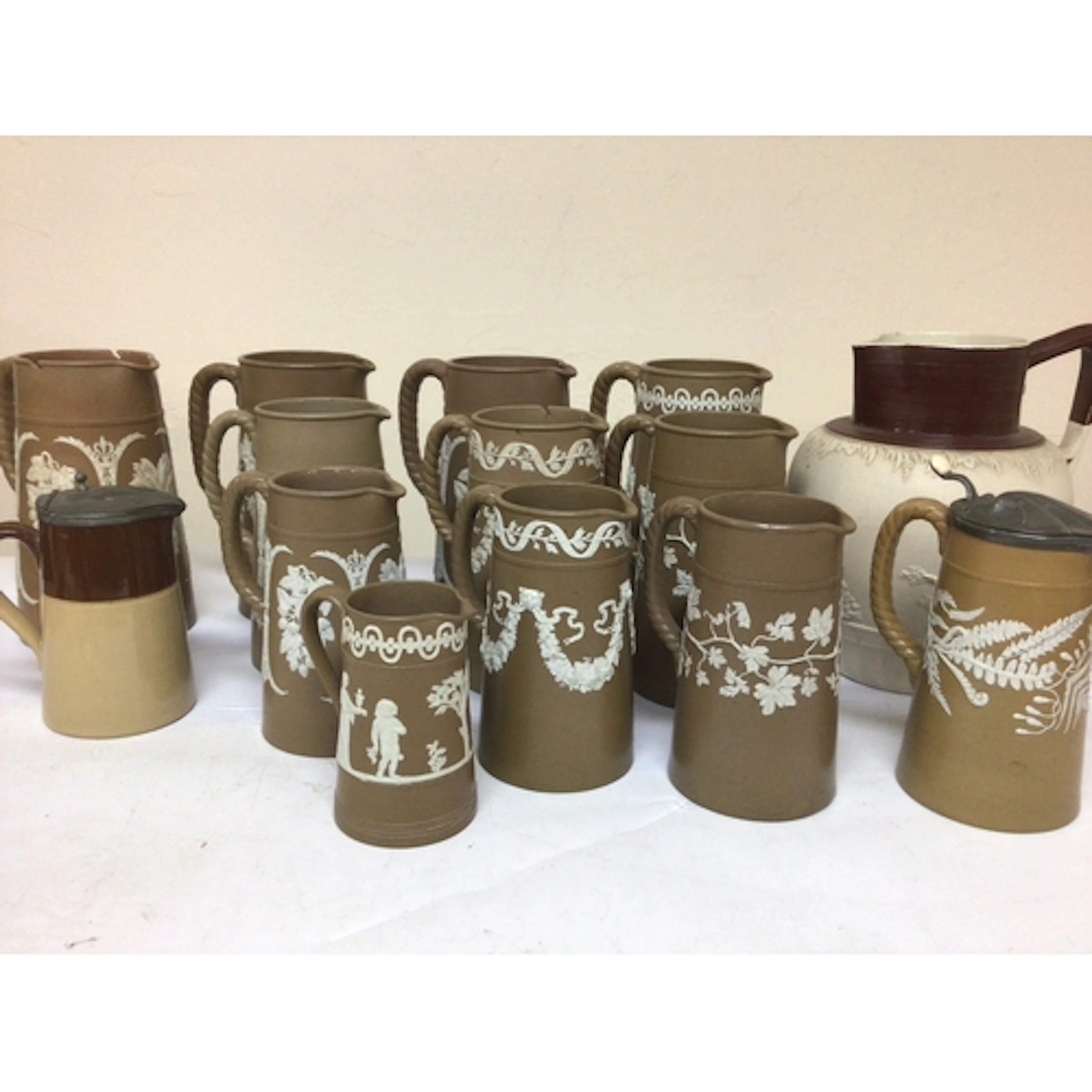 A collection of Victorian brown and white jugs decorat...