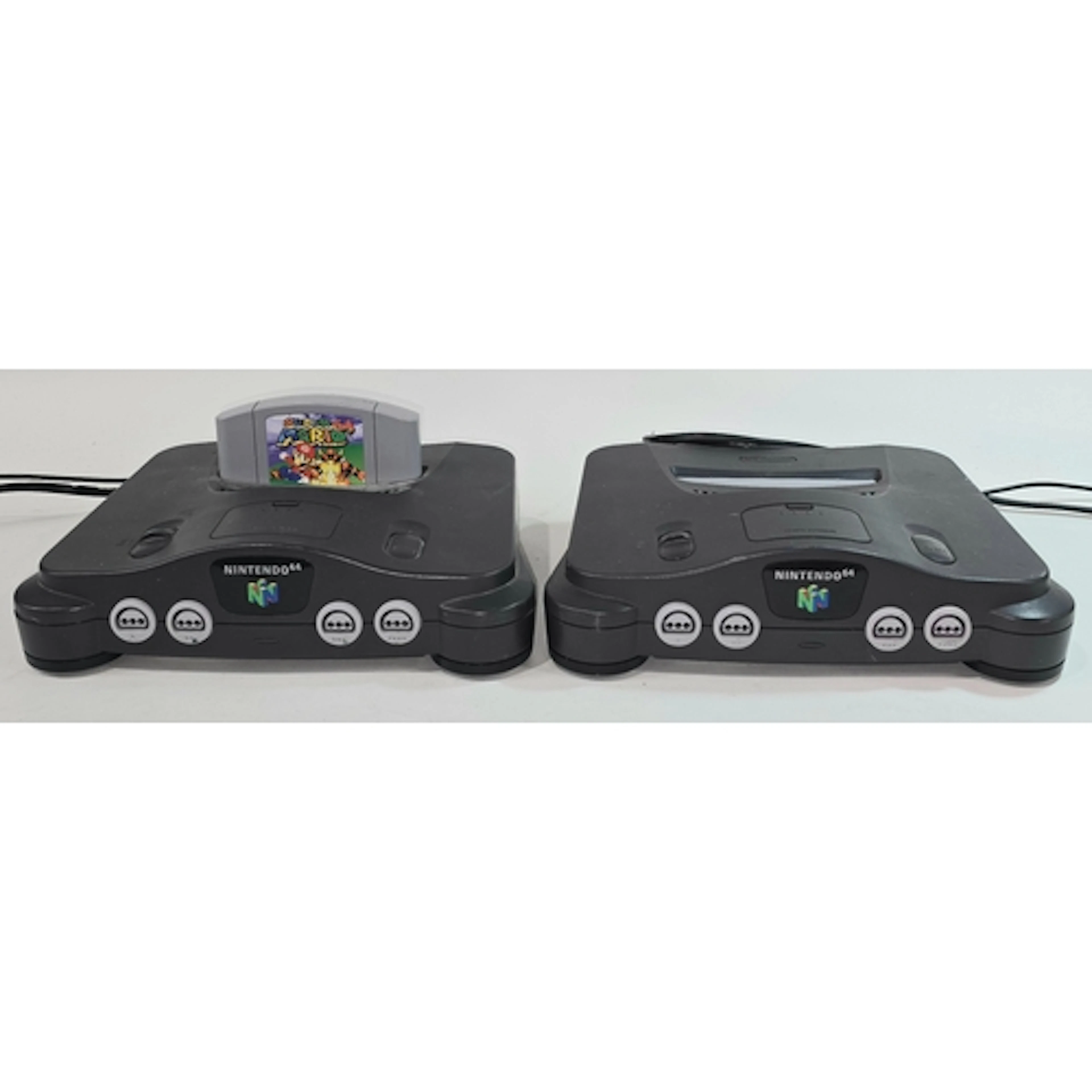 Two vintage Nintendo 64 gaming consoles both with associated...