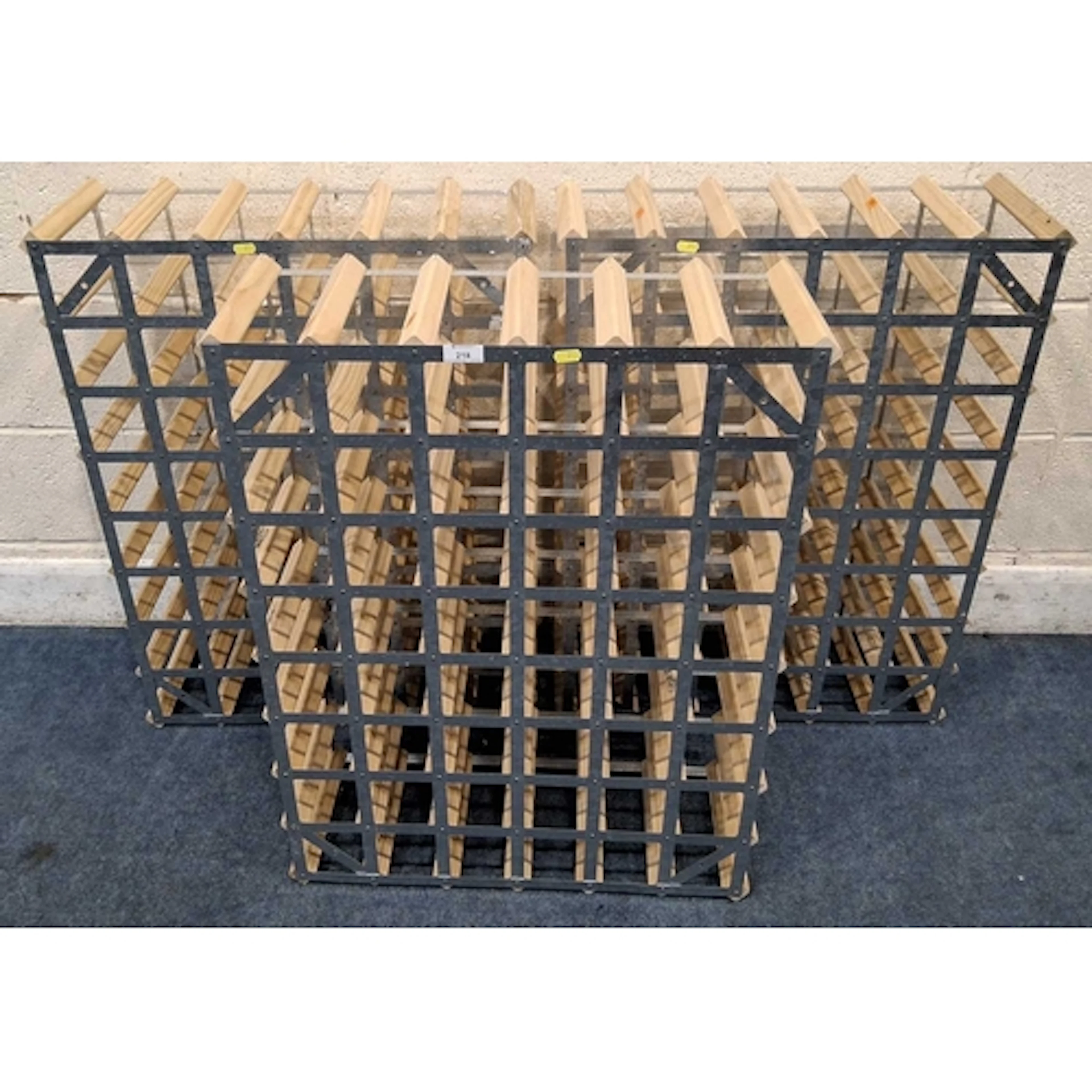 A SET OF THREE WOOD AND METAL WINE RACKS, each with forty-ei...