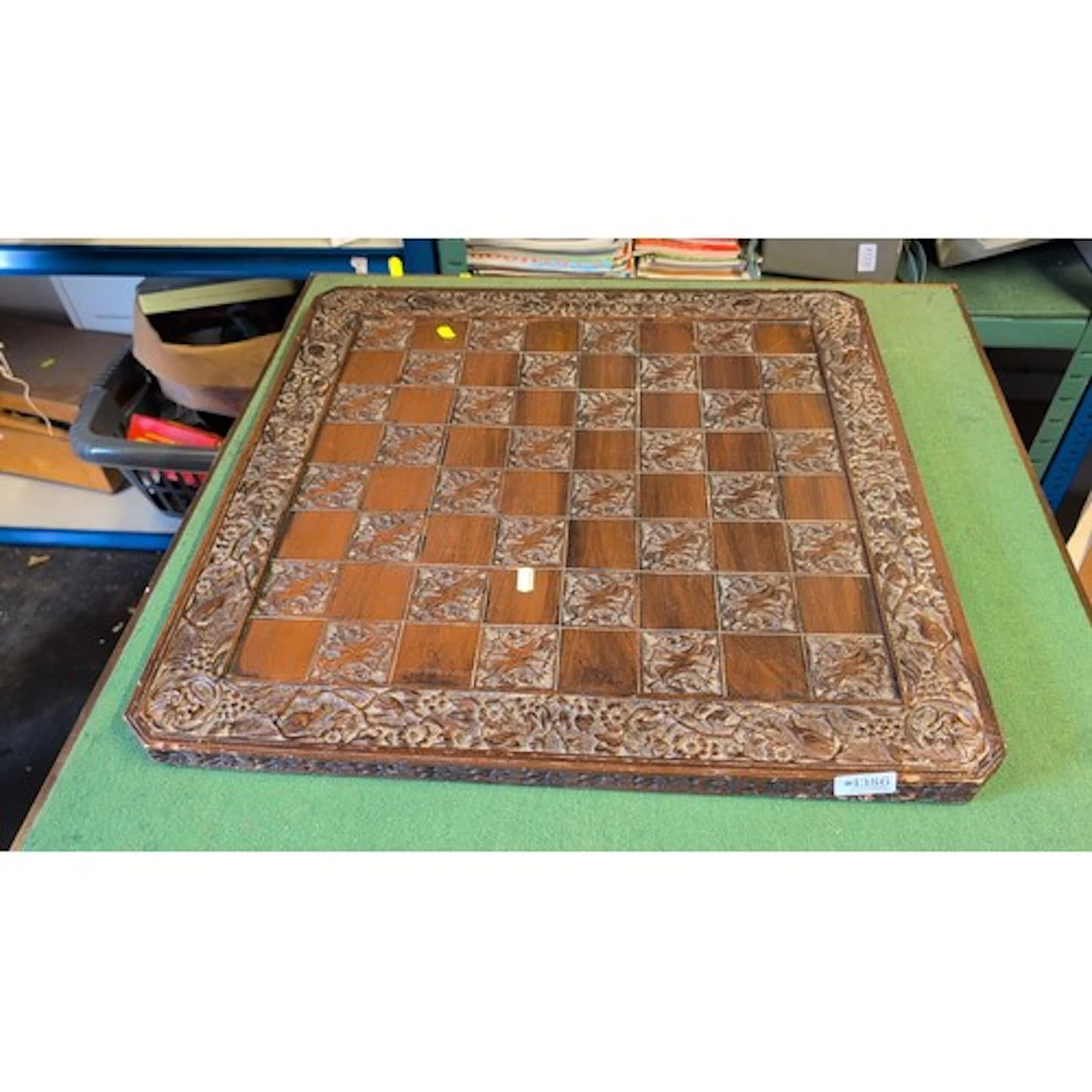 Carved wooden chessboard with alternating plain and dragon-d...