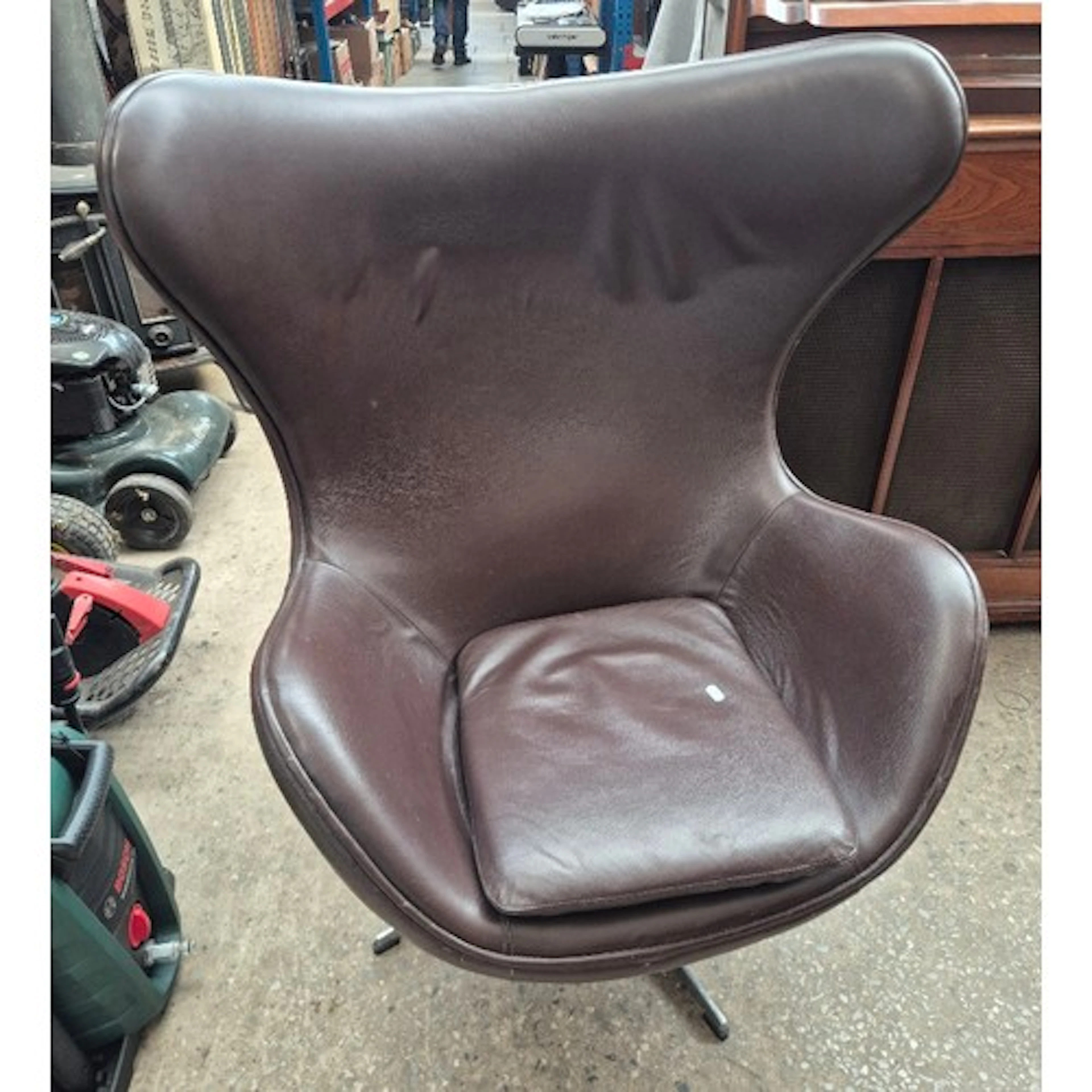 A brown leather egg chair in the manner of Arne Jacobsen for...