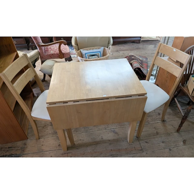 A light beech dropleaf kitchen or dining table with two matc...