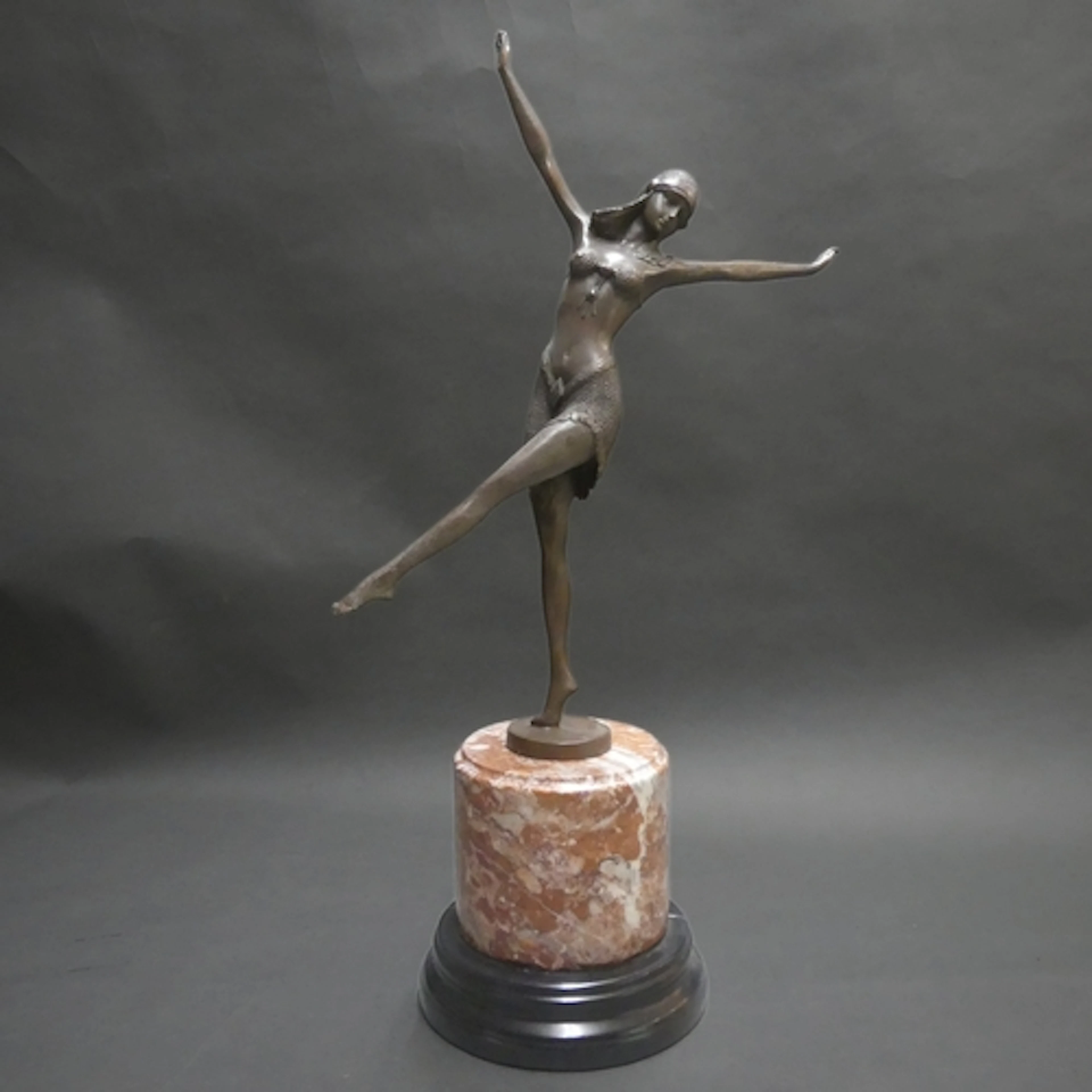An Art Deco style bronze figure on stepped red and black mar...