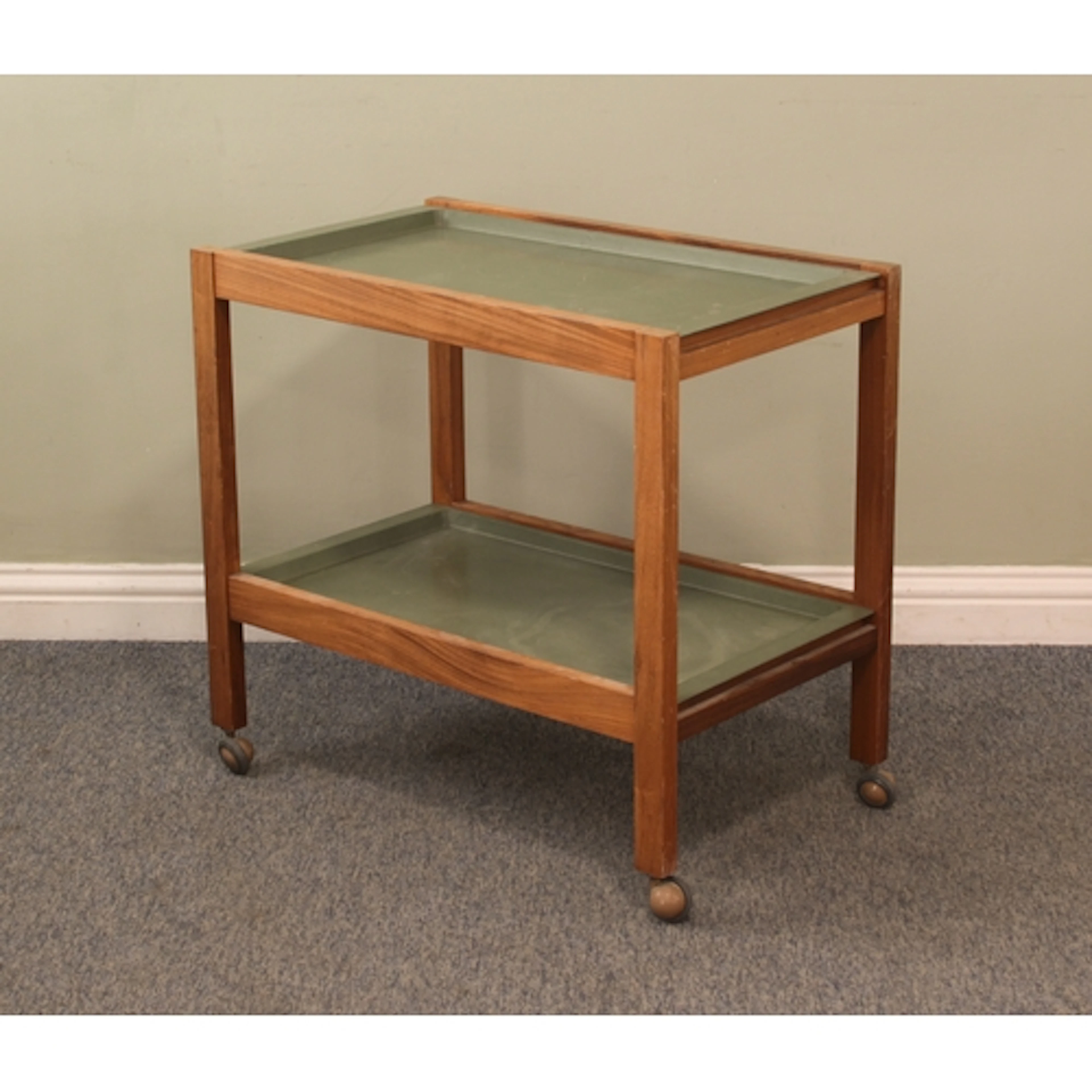 A vintage teak and green plastic two-tier drinks trolley - 1...