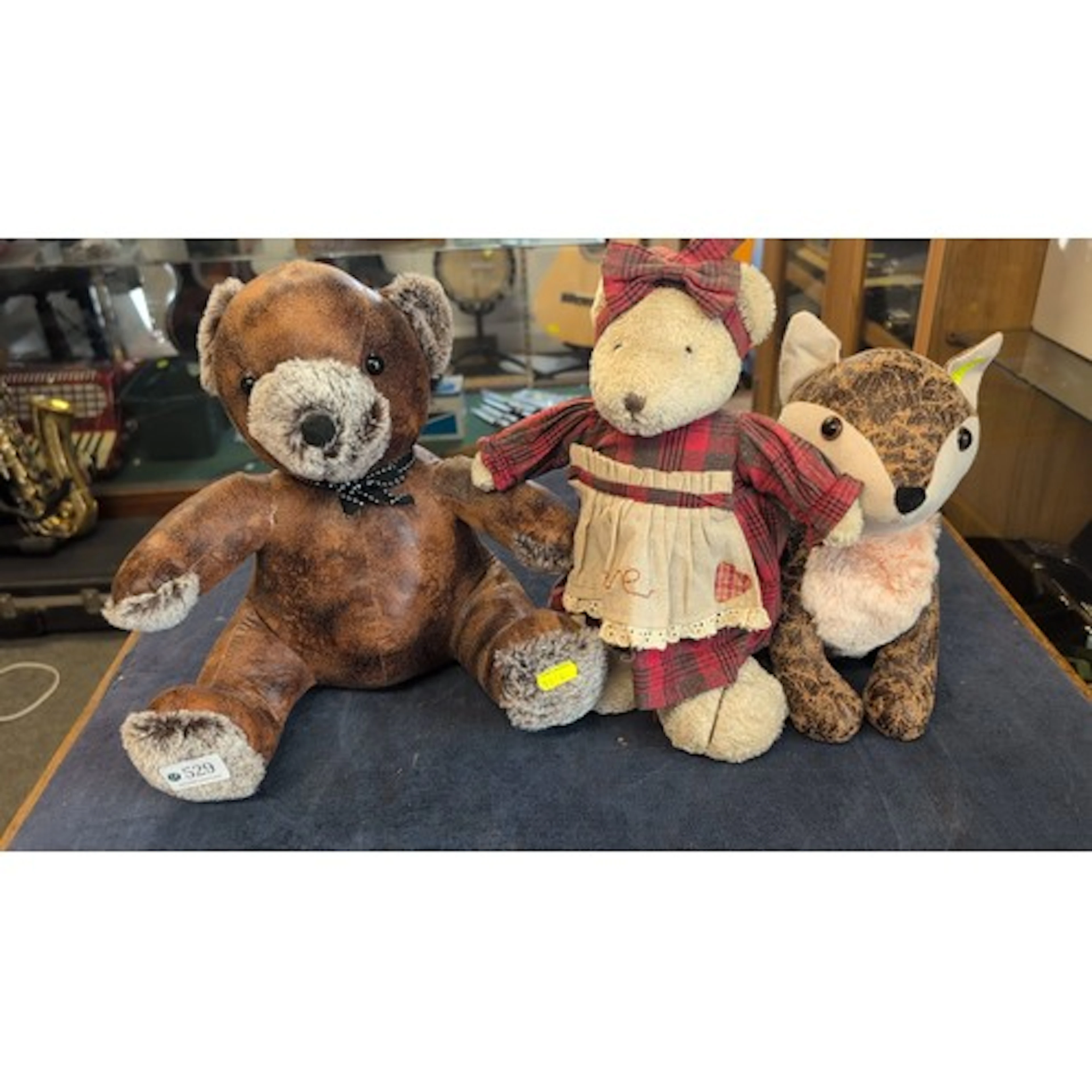 A group of three plush animal toys comprising a faux-leather...