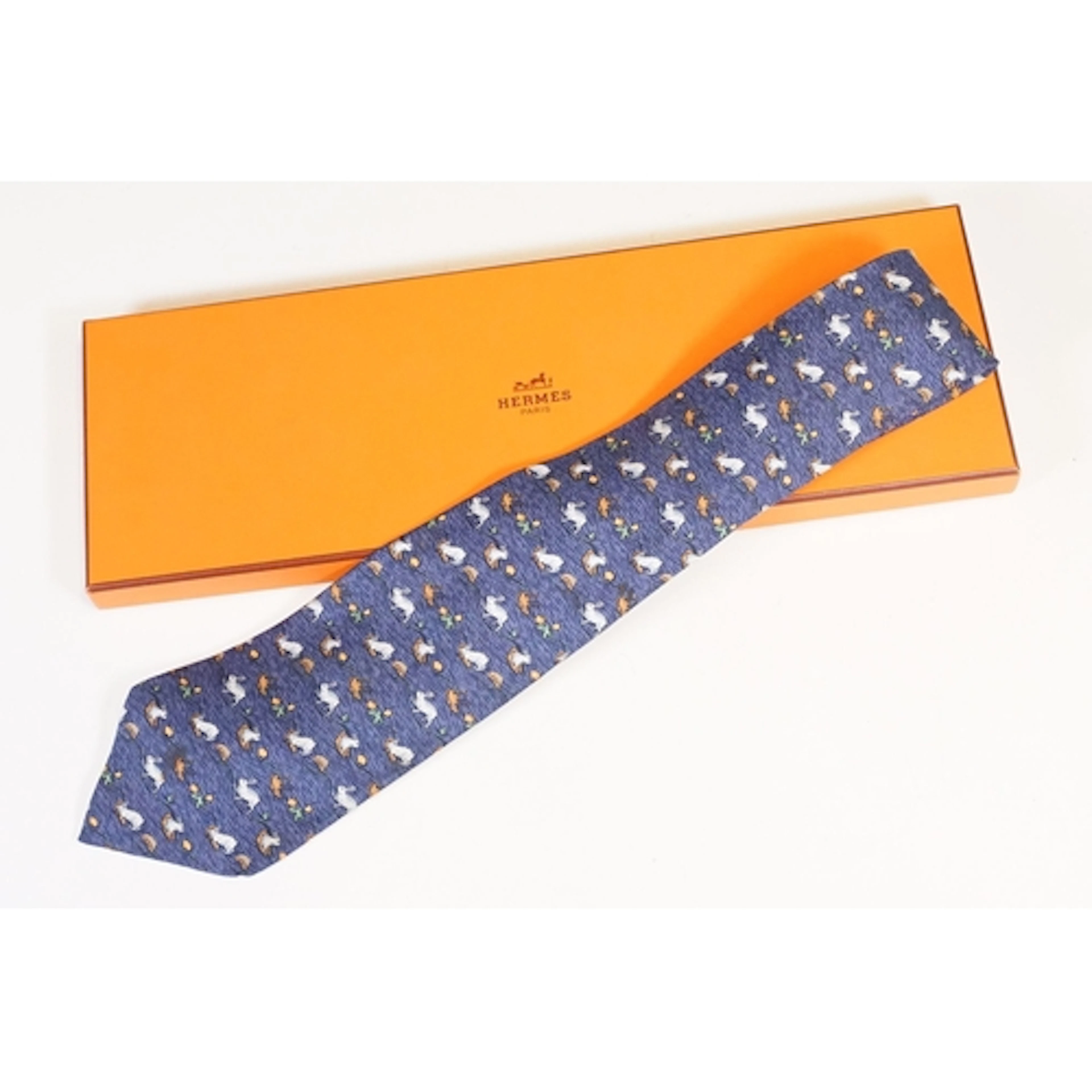 A Hermes 100% silk tie with decorative white rabbits, within...