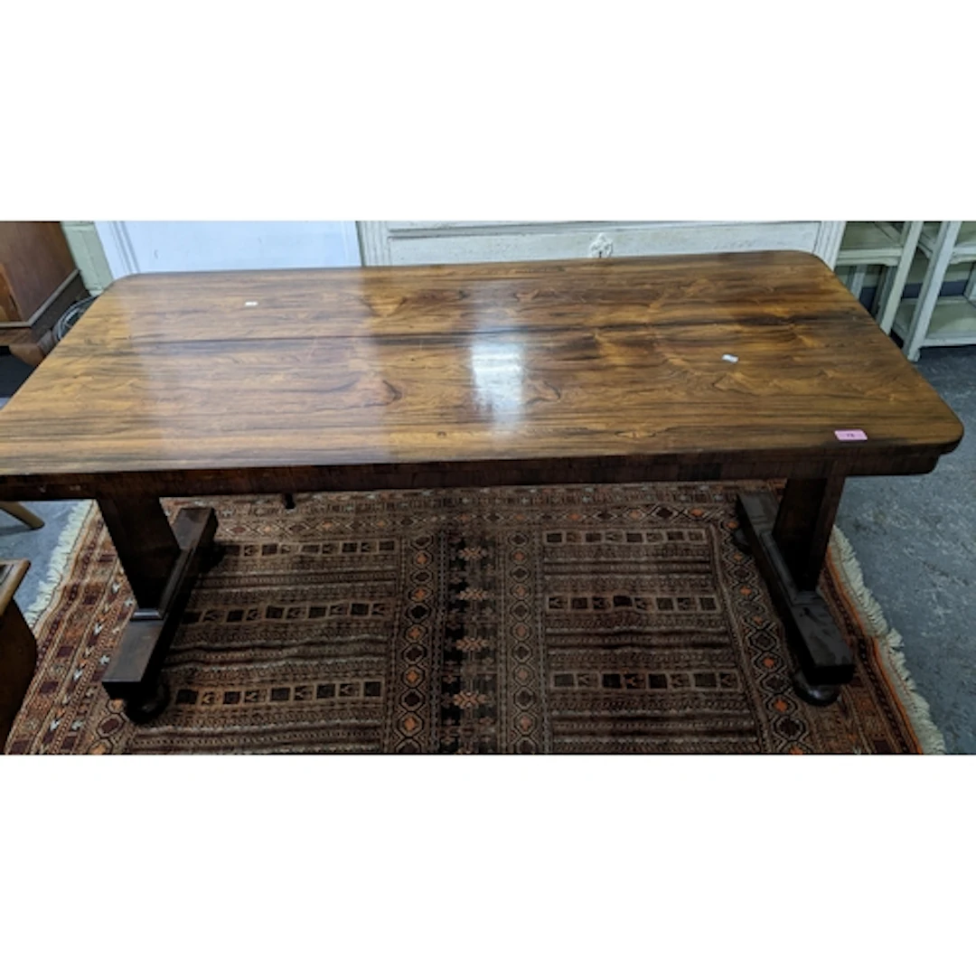 A Regency rosewood centre table, trestle ends, on cushioned ...