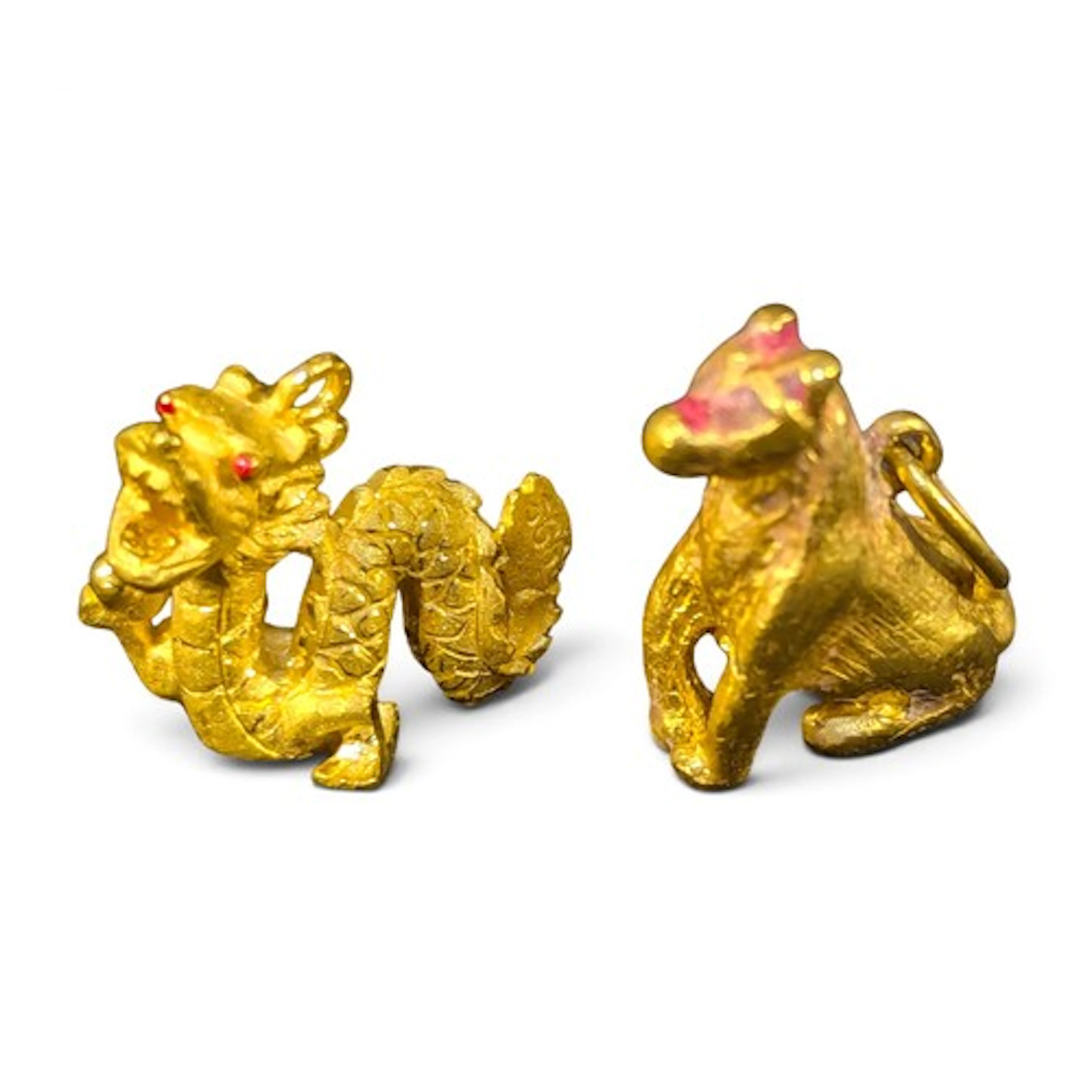 A Chinese yellow metal pendant charm cast as a dragon, stamp...