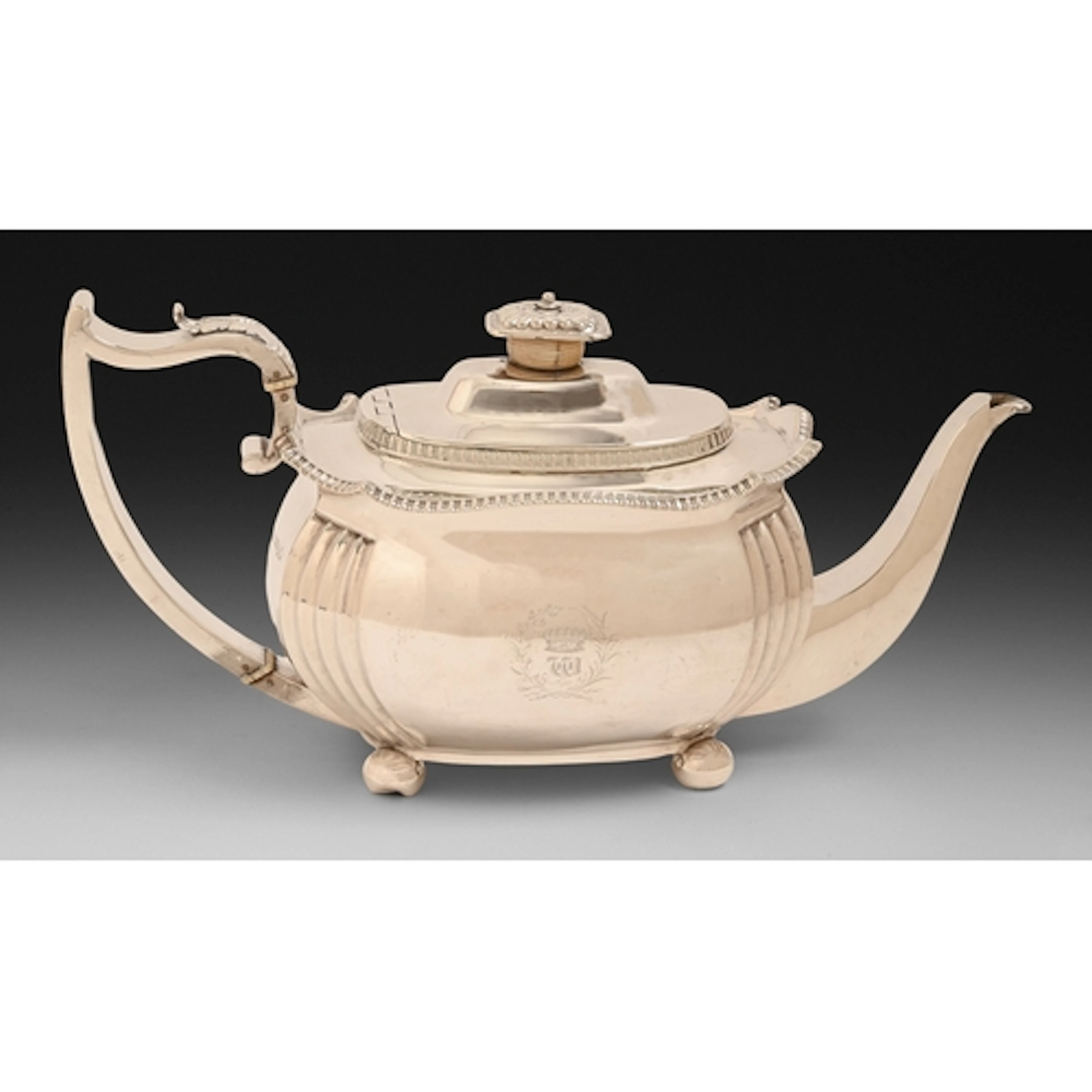 A George III silver teapot, with flush joint to the domed li...