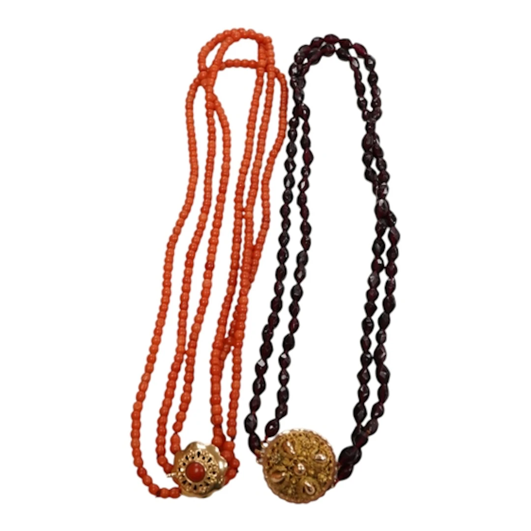 A twin strand facet cut garnet bead necklace with filigree y...