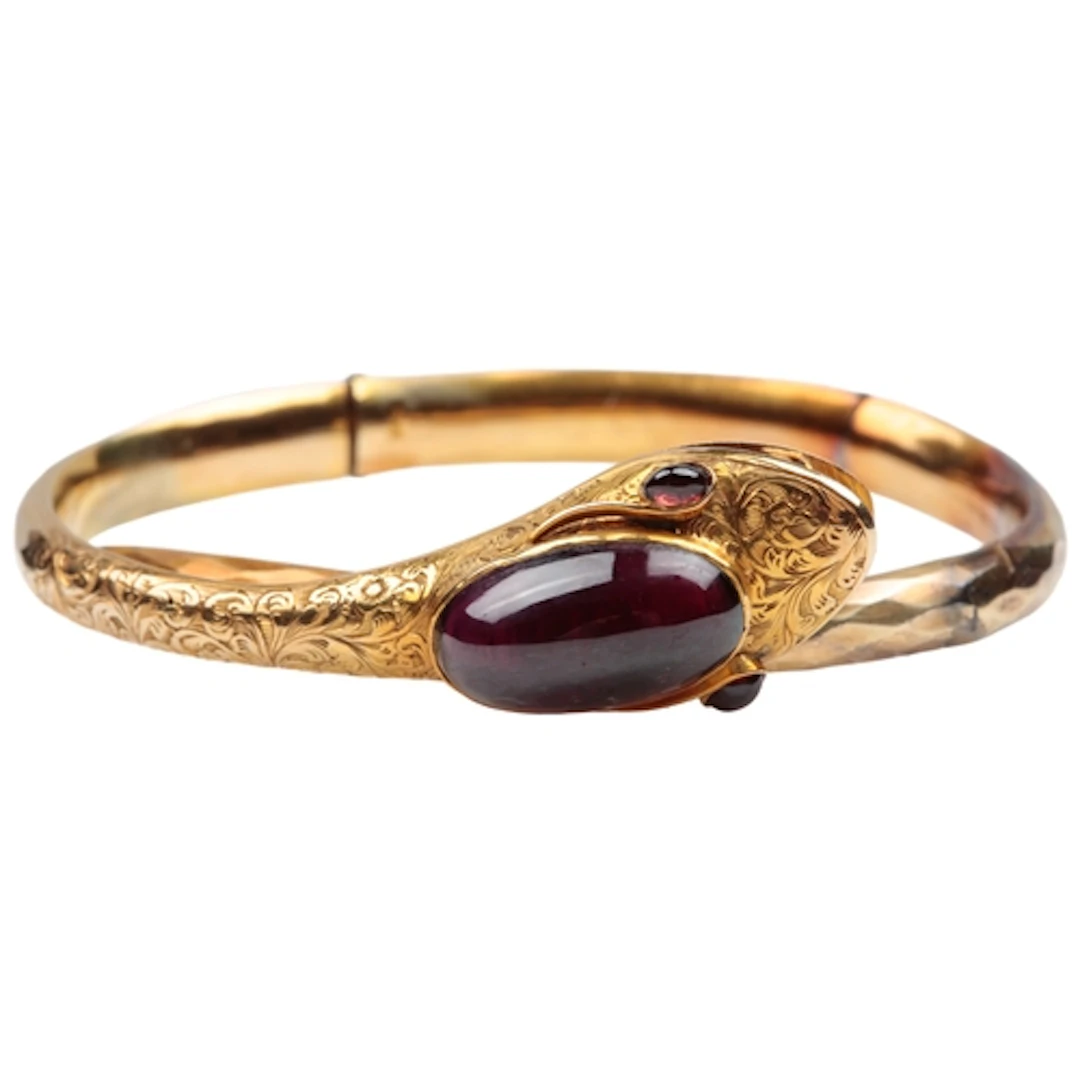 A Victorian gold and garnet snake bangle, mid 19th century, ...
