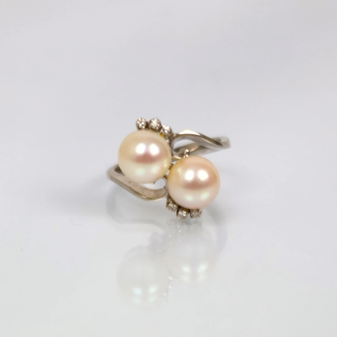 A mid 20th century cultured pearl 'toi et moi' ring, the two...