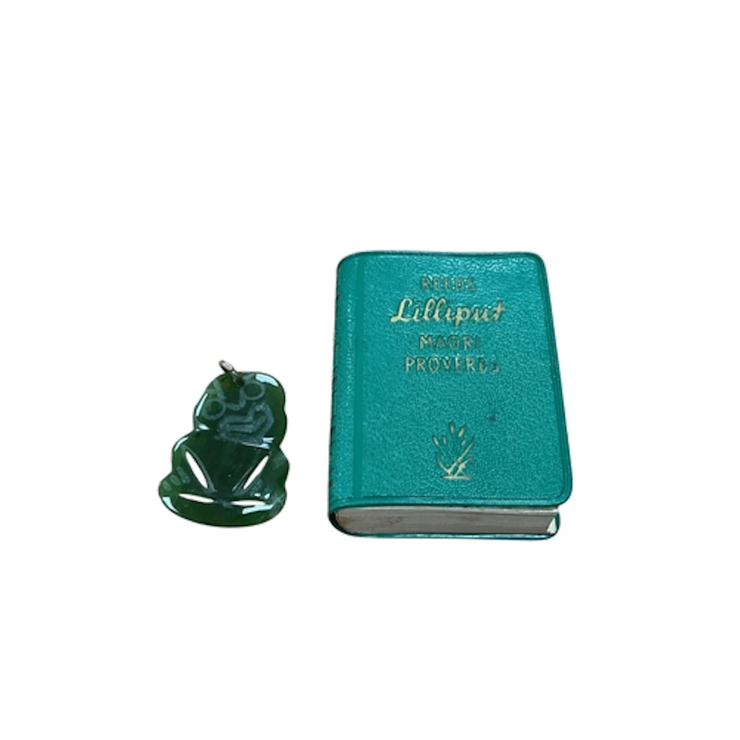 A New Zealand Tiki jade pendant, and related miniature book,...