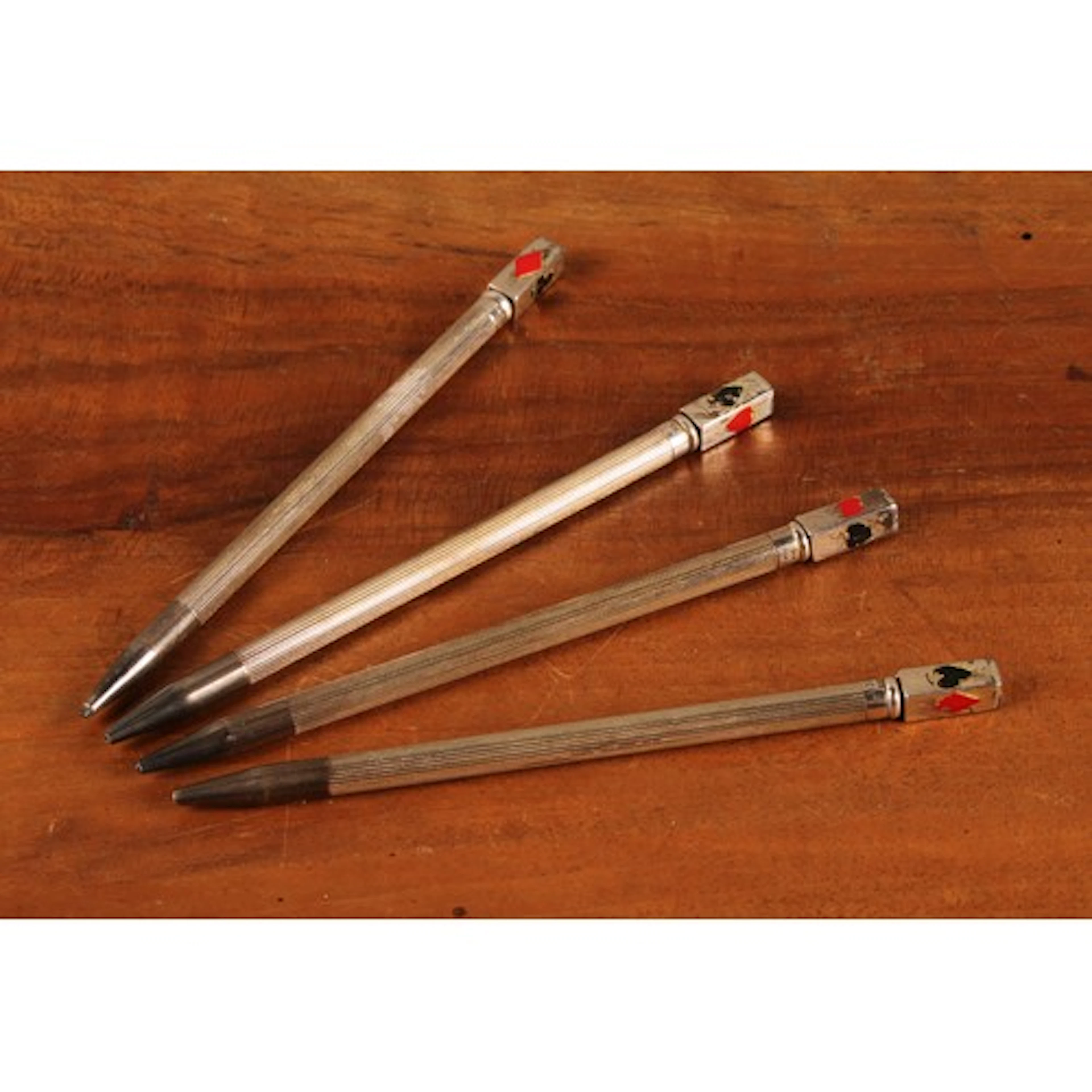 A set of four Elizabeth II silver bridge pencils, decorated ...