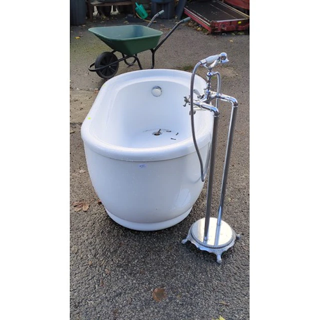 White freestanding oval bathtub with a rolled rim and pedest...