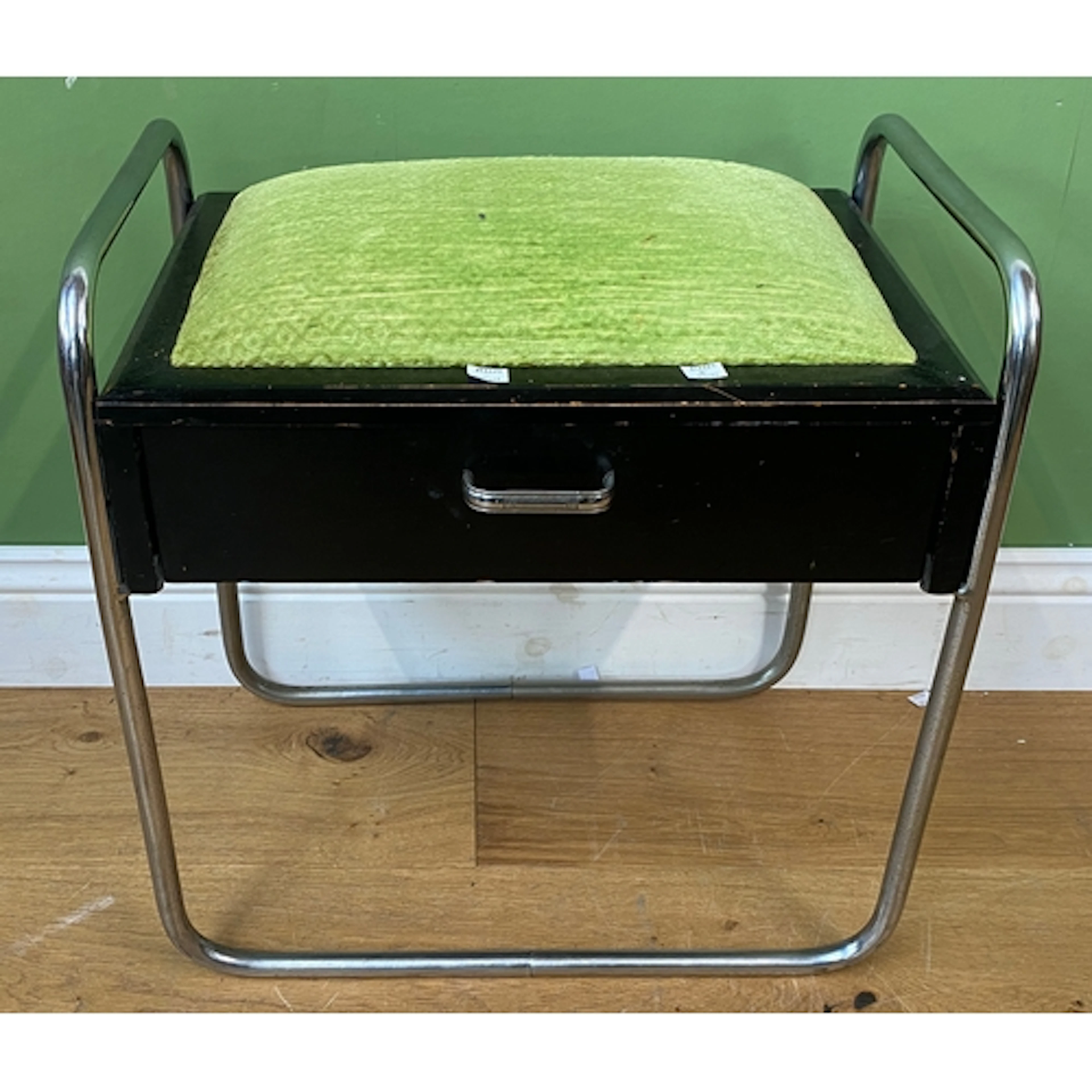 A black painted and chrome piano stool with a venom green se...