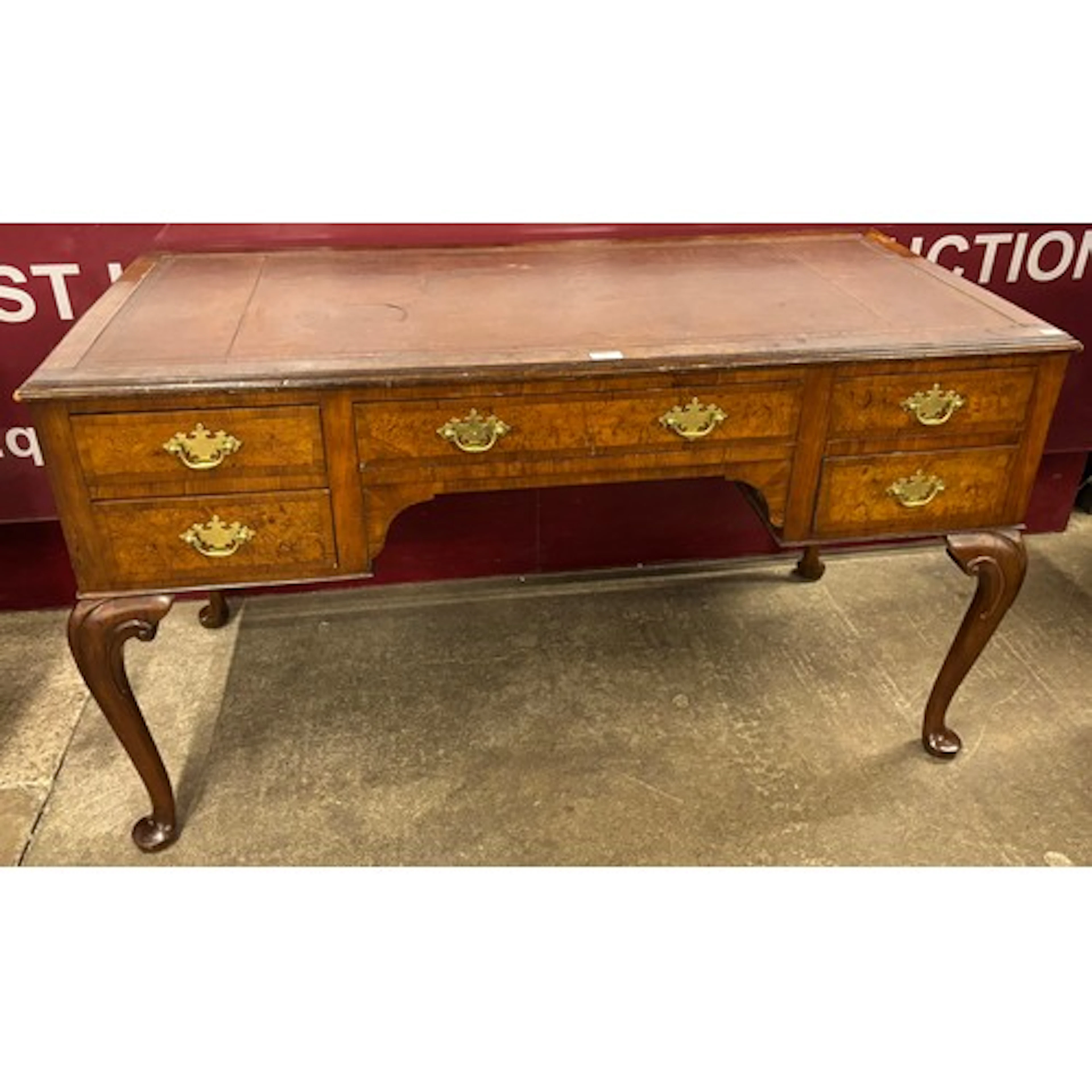 A Queen Anne style walnut and red leather topped desk