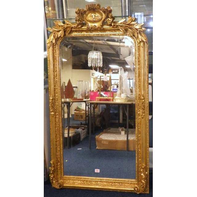 A French style gilt framed bevelled mirror moulded with scro...
