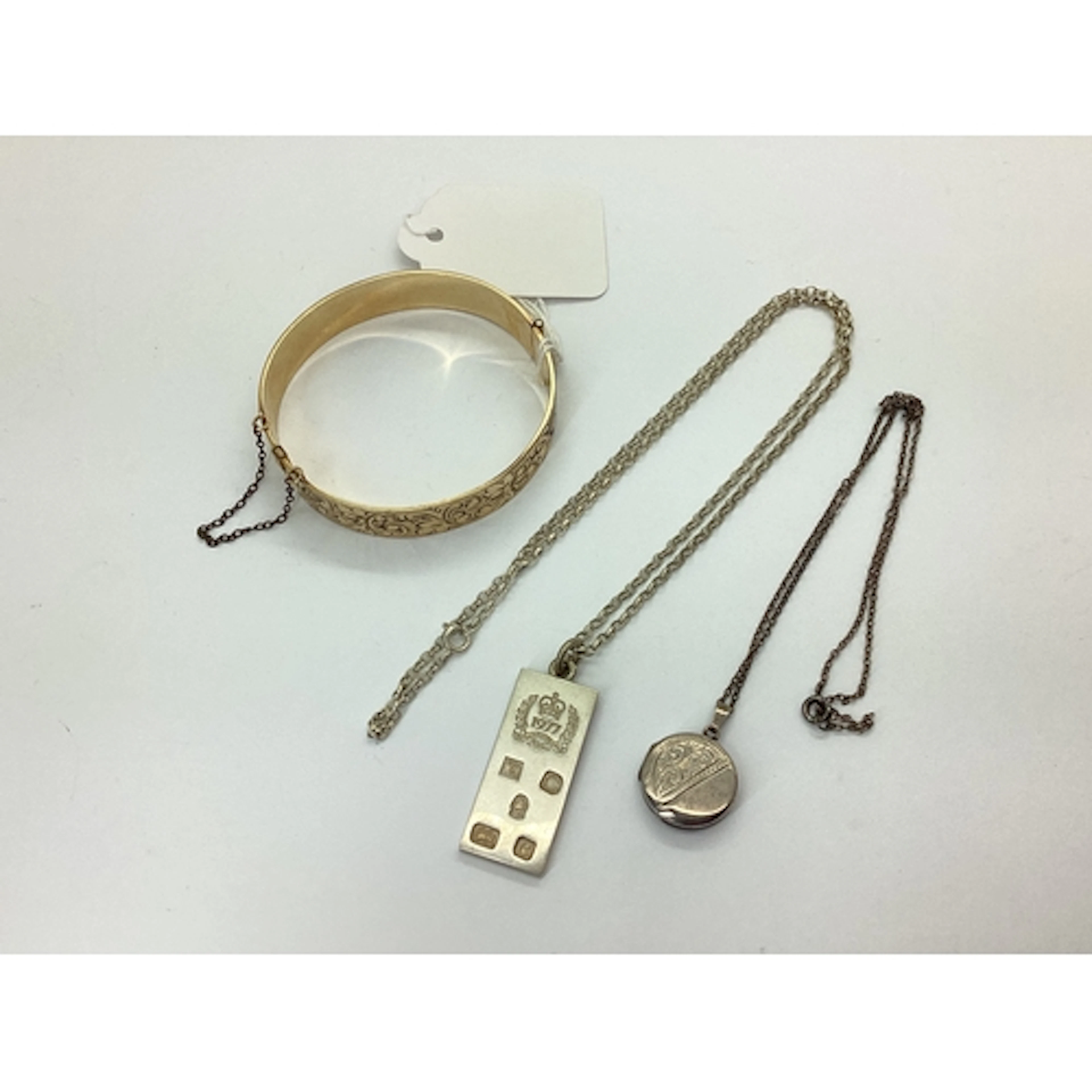 A Hallmarked Silver 1977 Ingot Pendant, together with a circ...