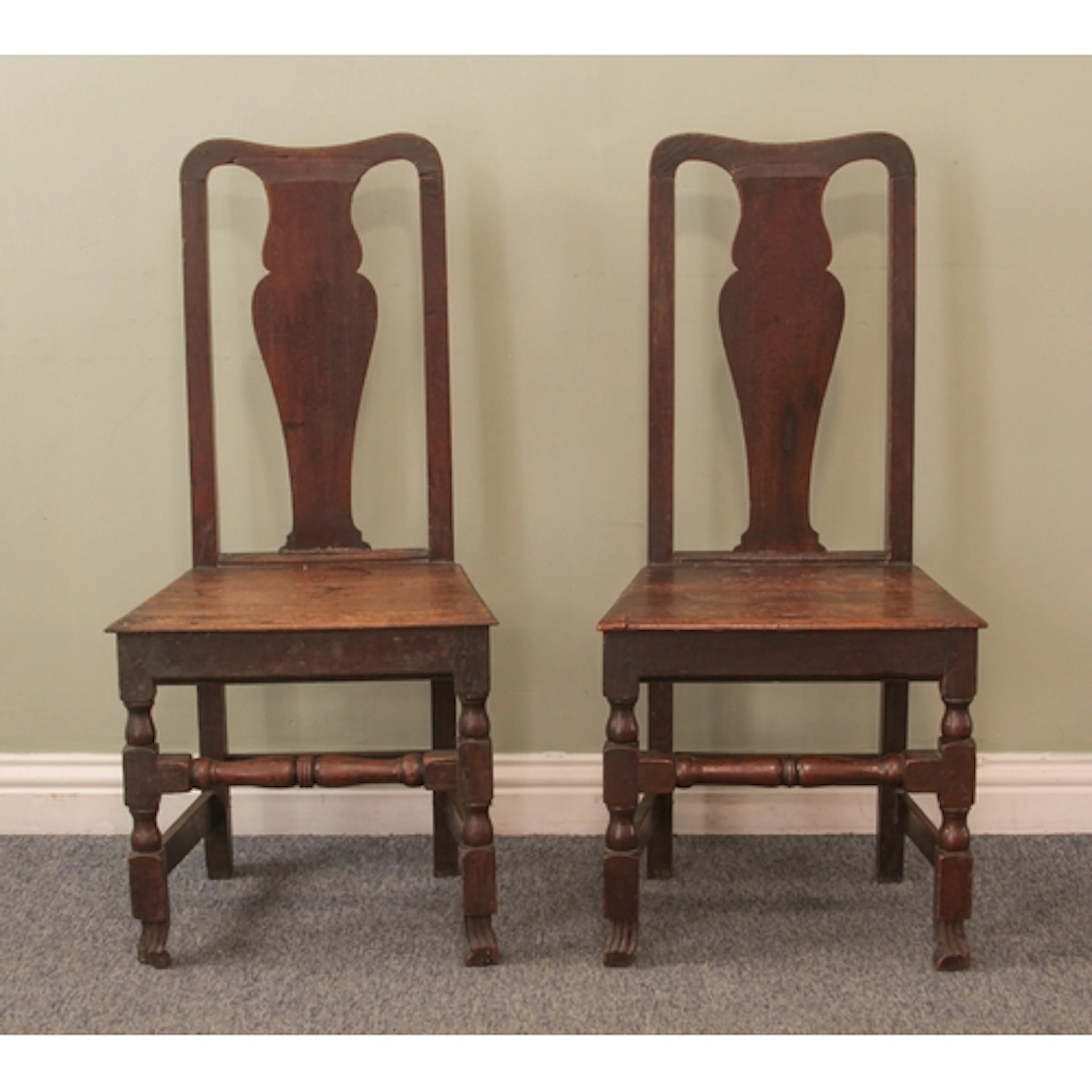 A pair of 18th century oak hall chairs - the upright backs w...
