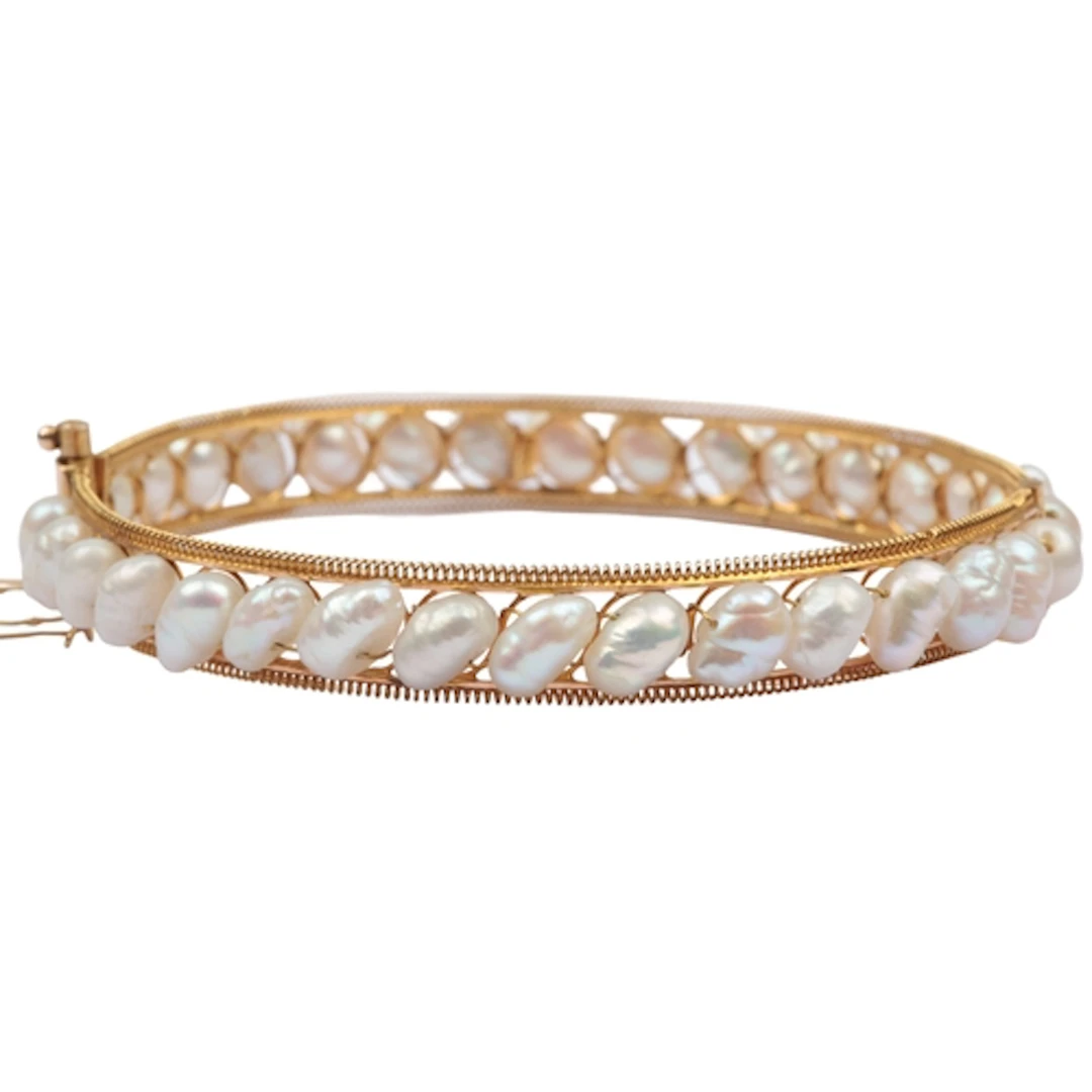 A cultured pearl bangle, the hinged gold bangle centring on ...