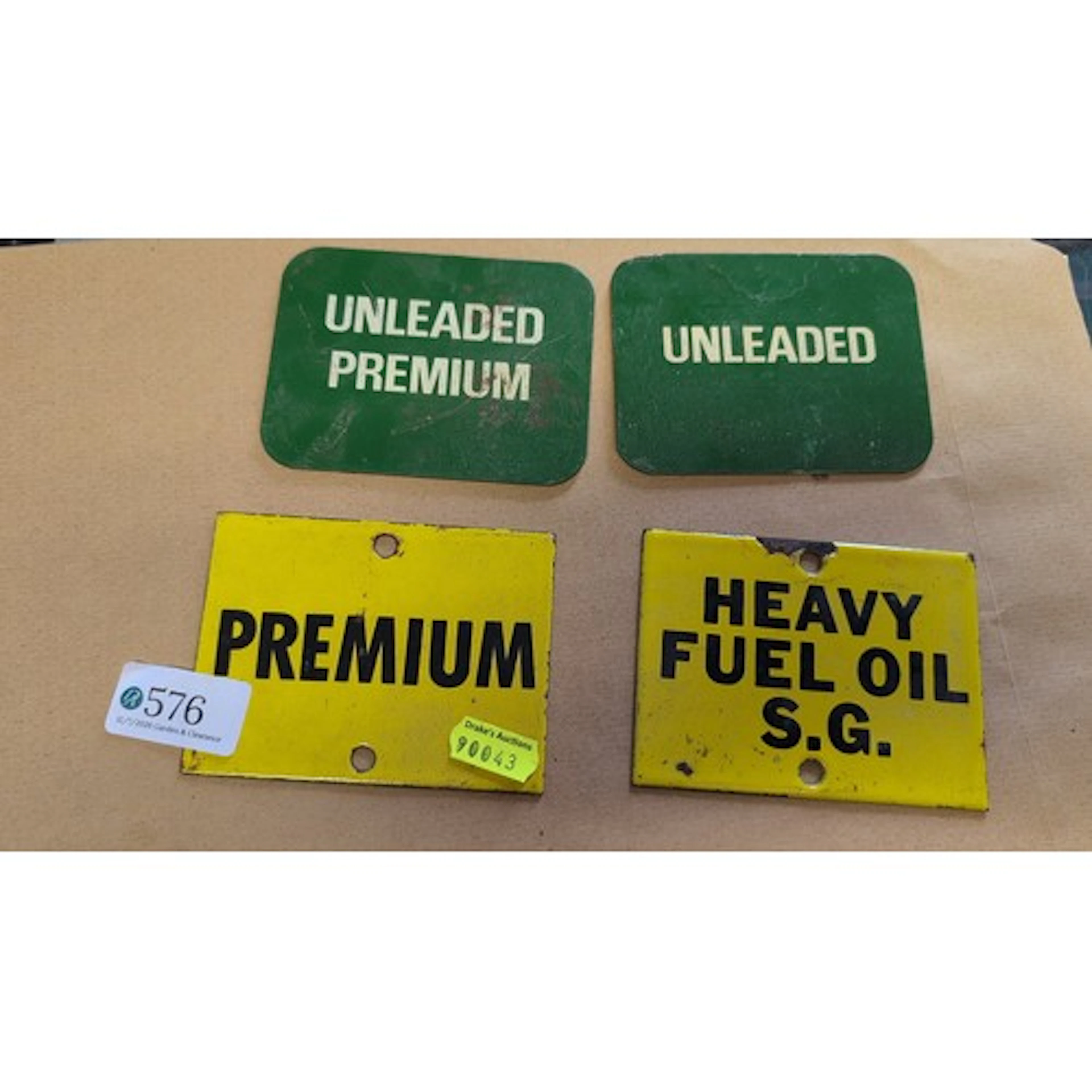 A group of four painted metal pump placards, comprising gree...