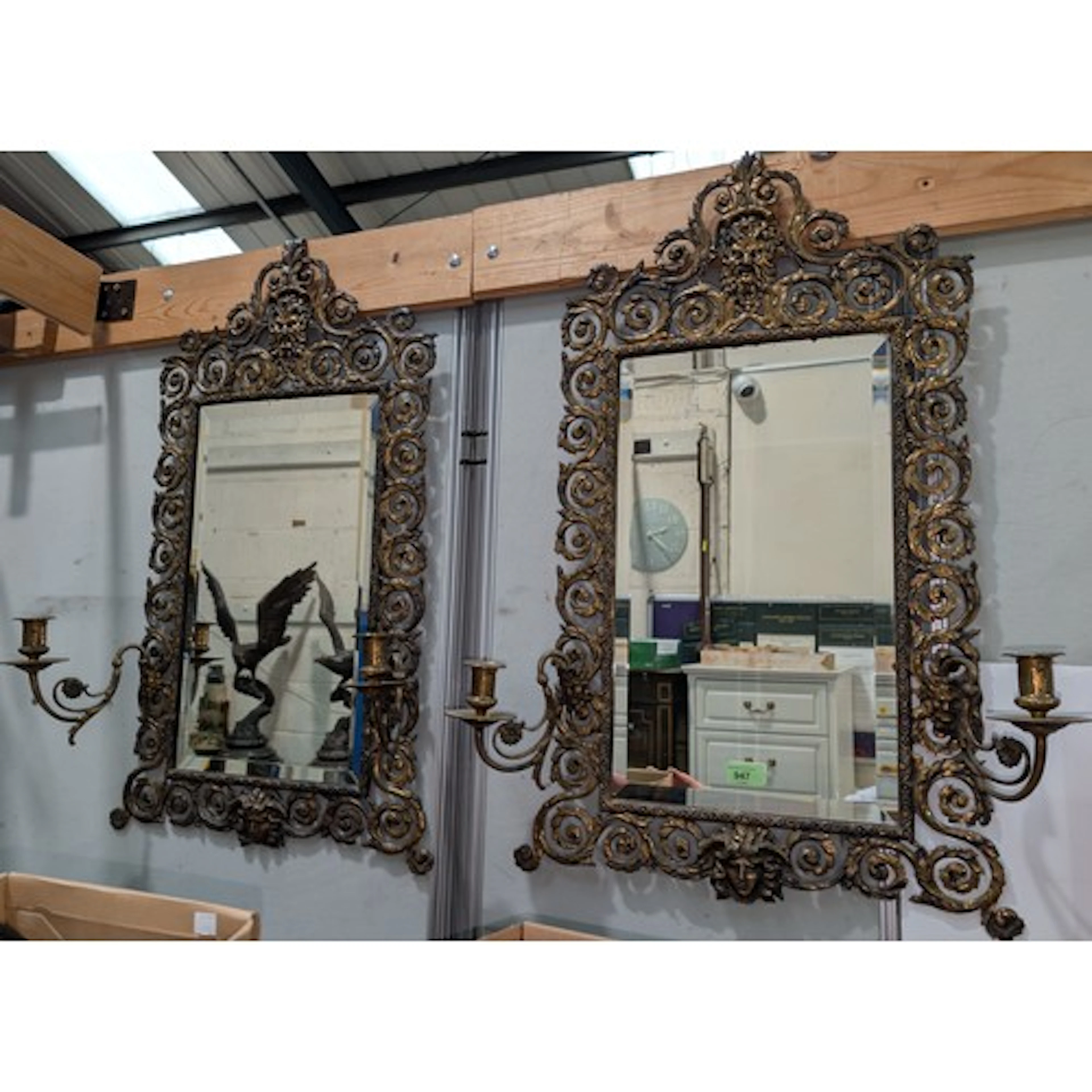 A pair of gothic brass framed wall mirrors with candle sconc...