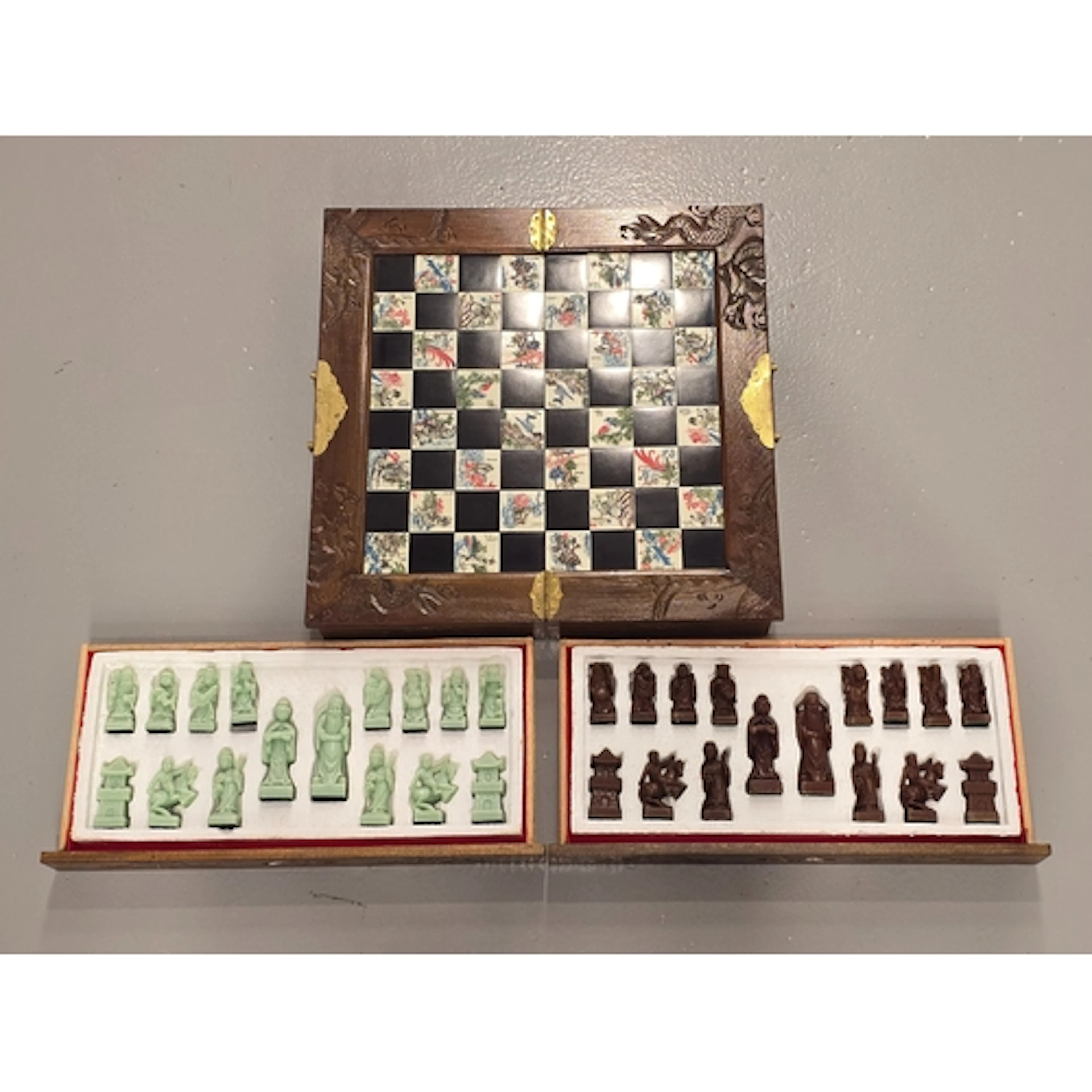 A vintage Chinese carved wood and tile chess set featuring a...