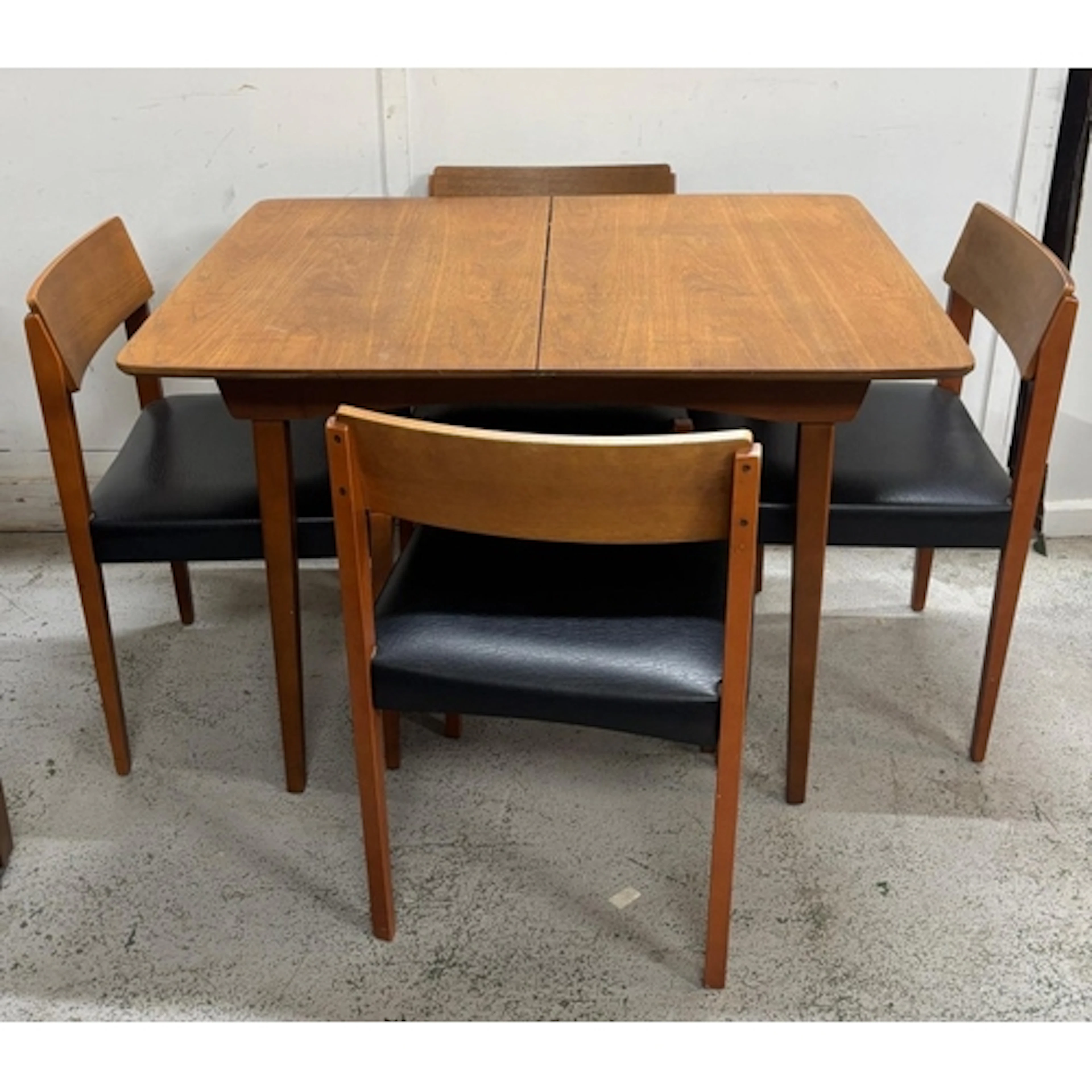 A Mid Century teak and extending dining table with four chai...