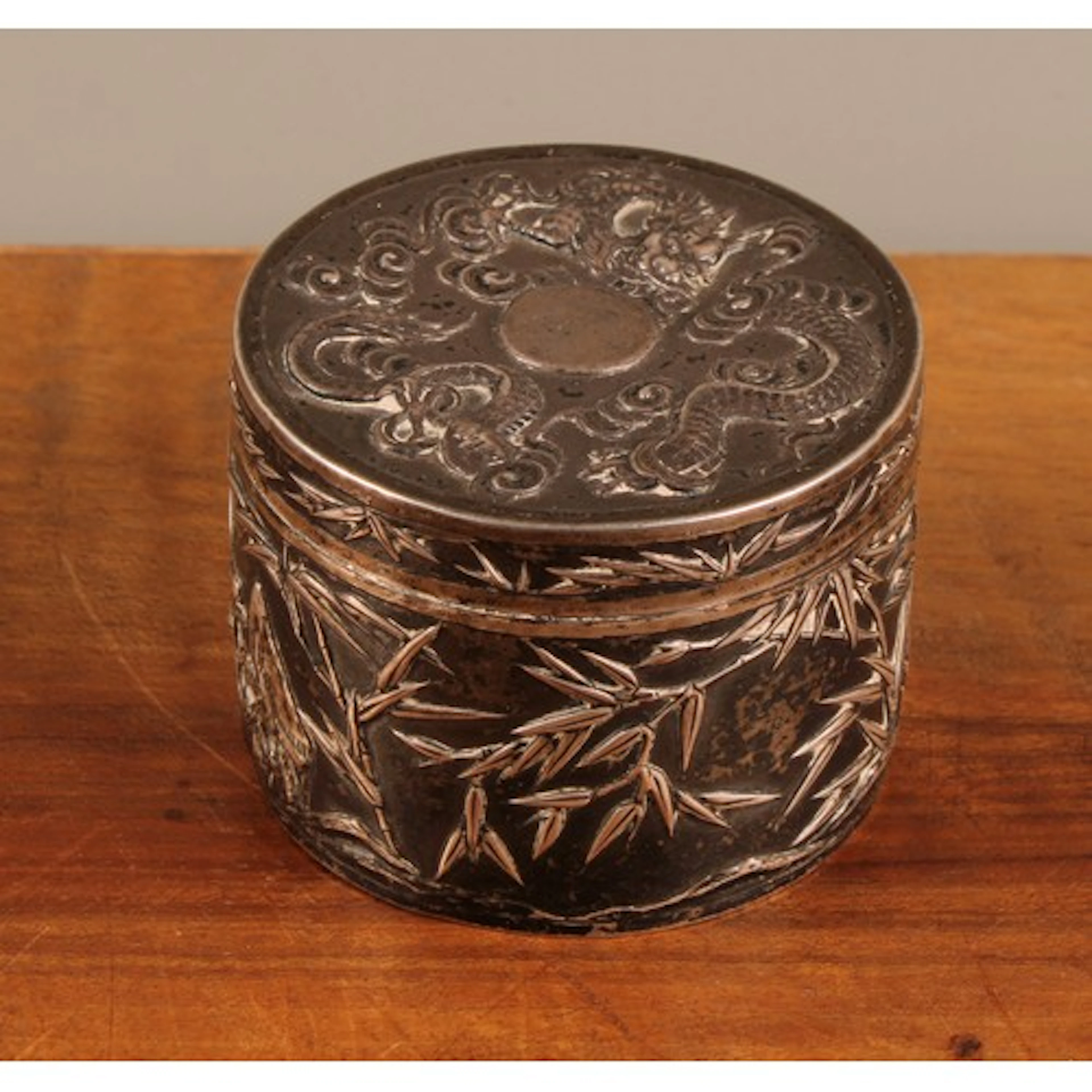A Chinese export silver circular box and cover, chased with ...