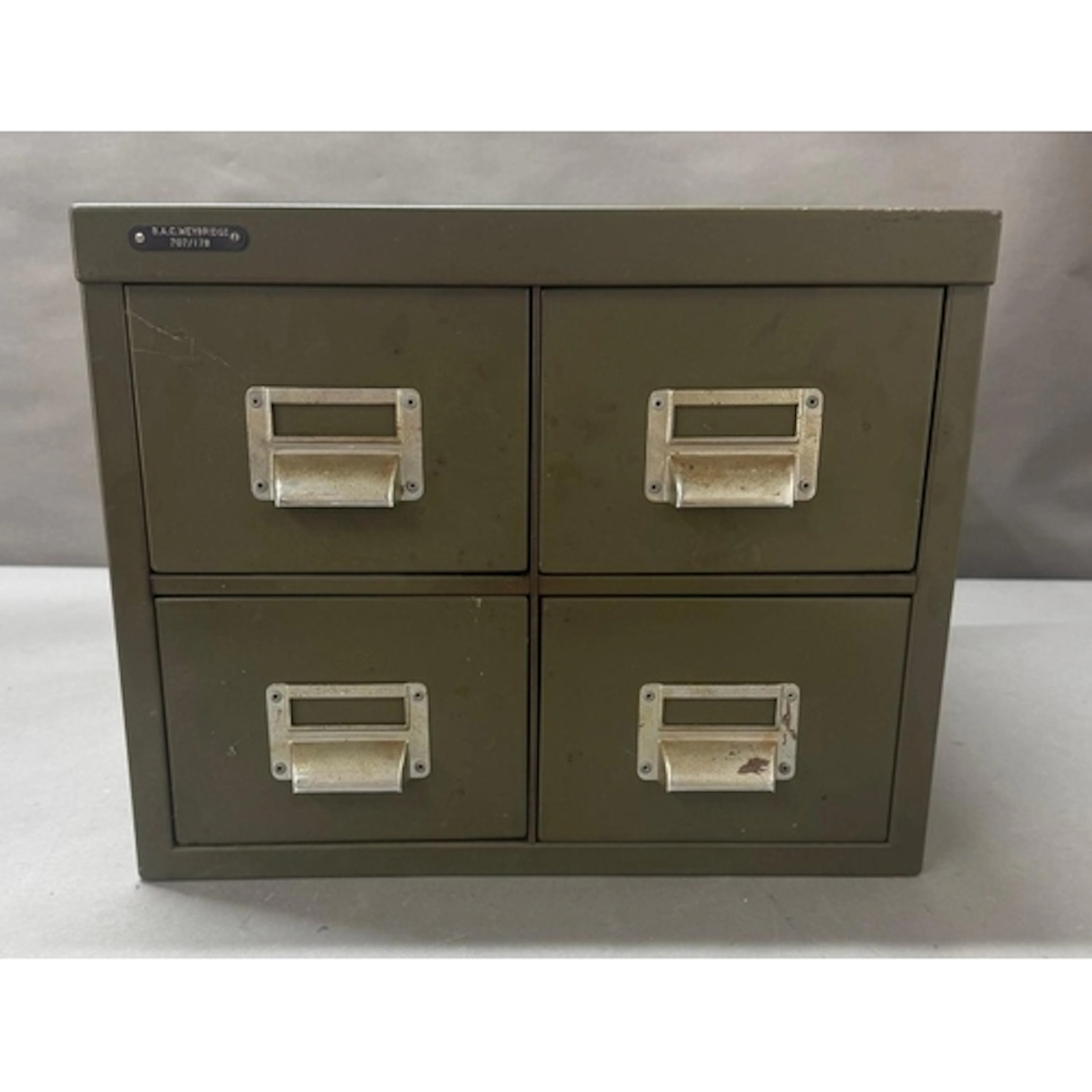 A green metal four drawer counter top index card filing cabi...