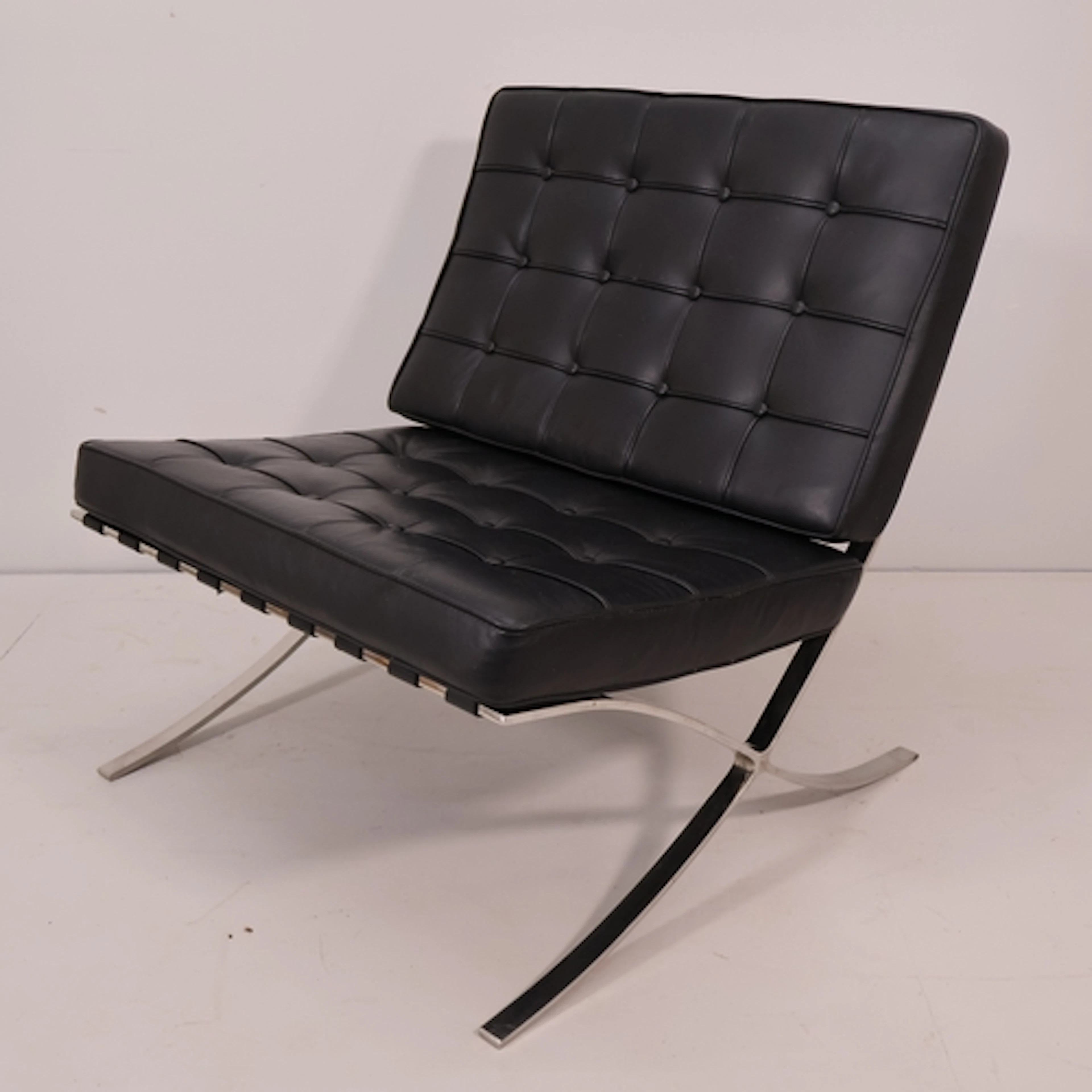 A contemporary faux leather upholstered Barcelona style loun...