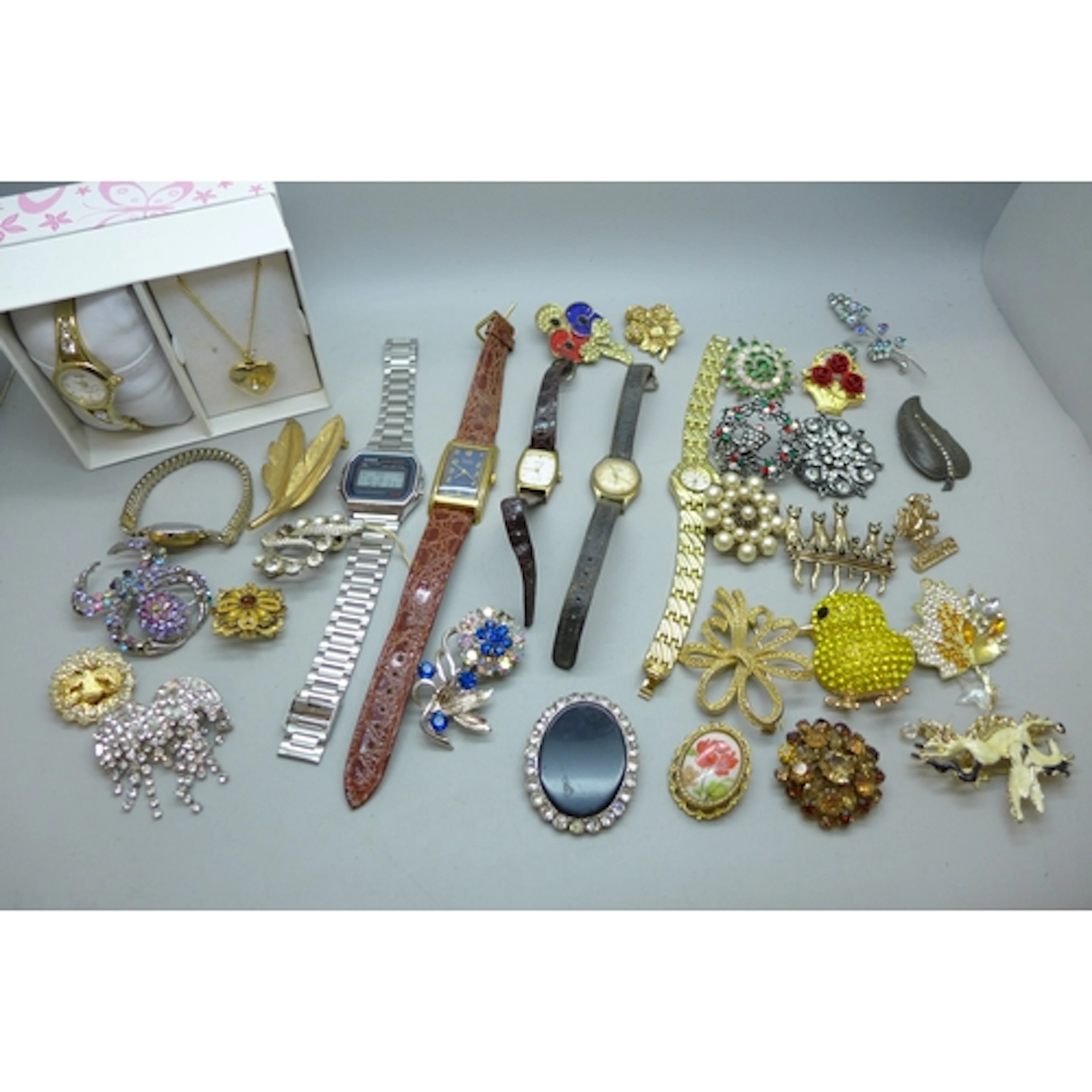 A collection of costume brooches and watches including Casio...