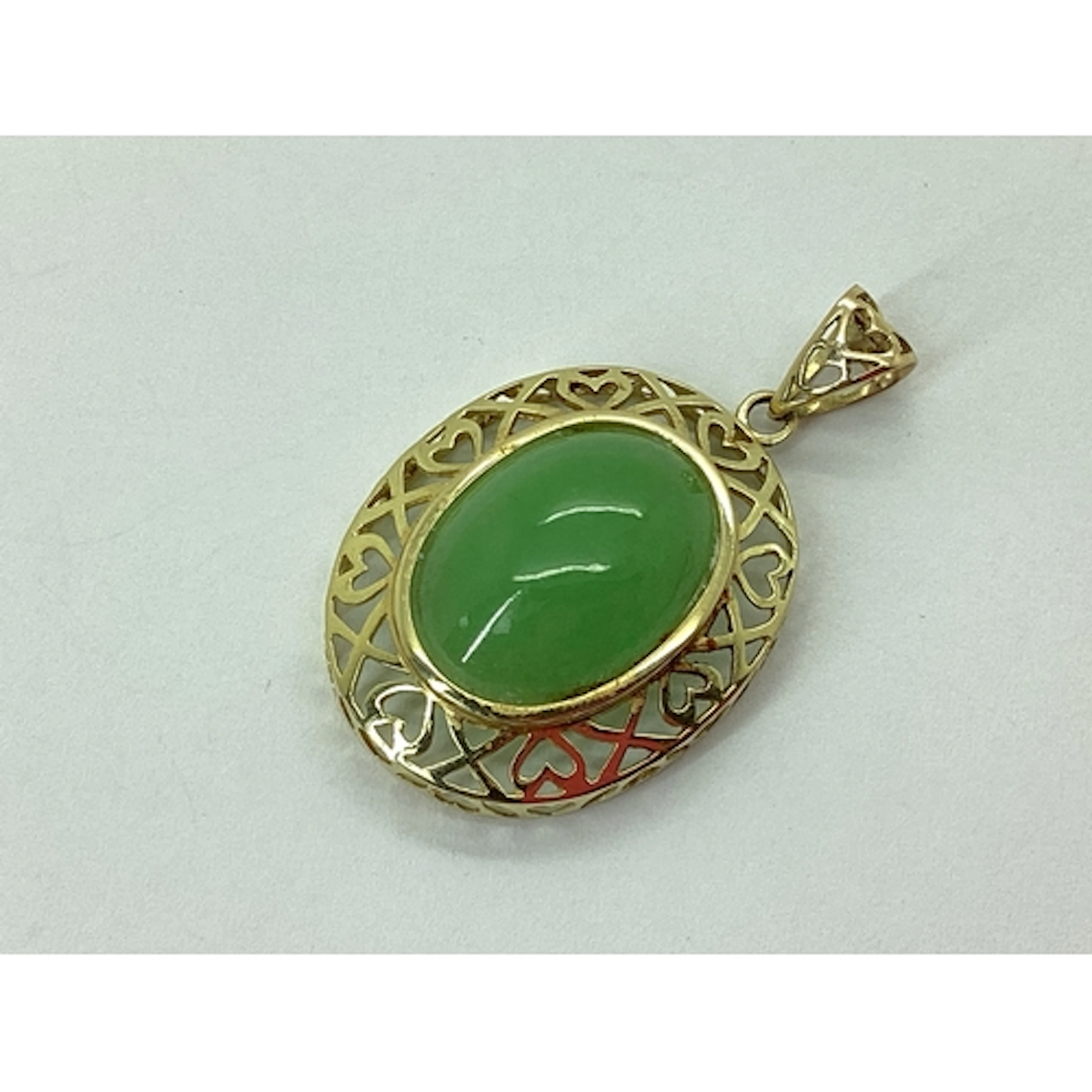 A Modern Jade Pendant, oval collet set within pierced heart ...