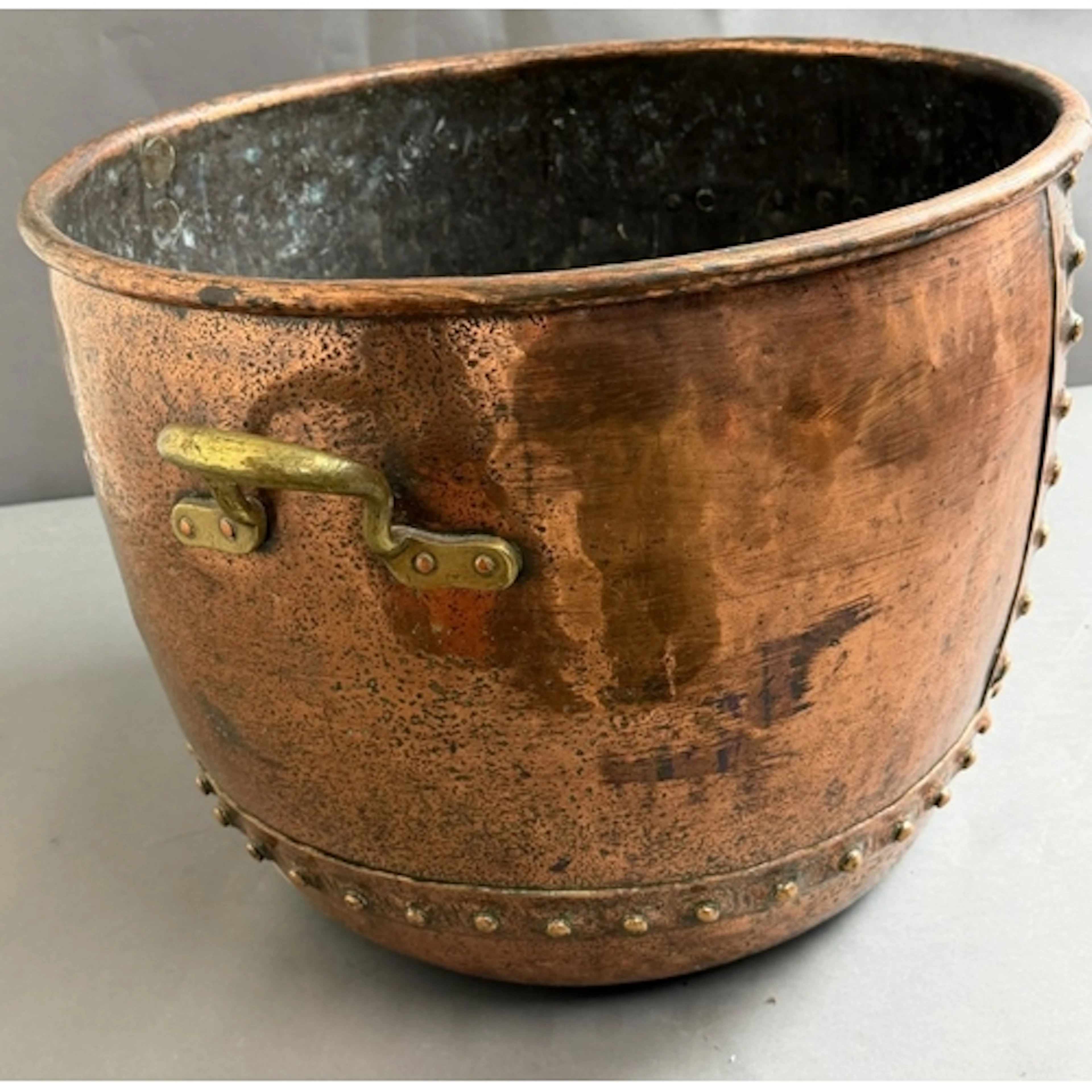 A large riveted copper cauldron, featuring vertical seam wit...