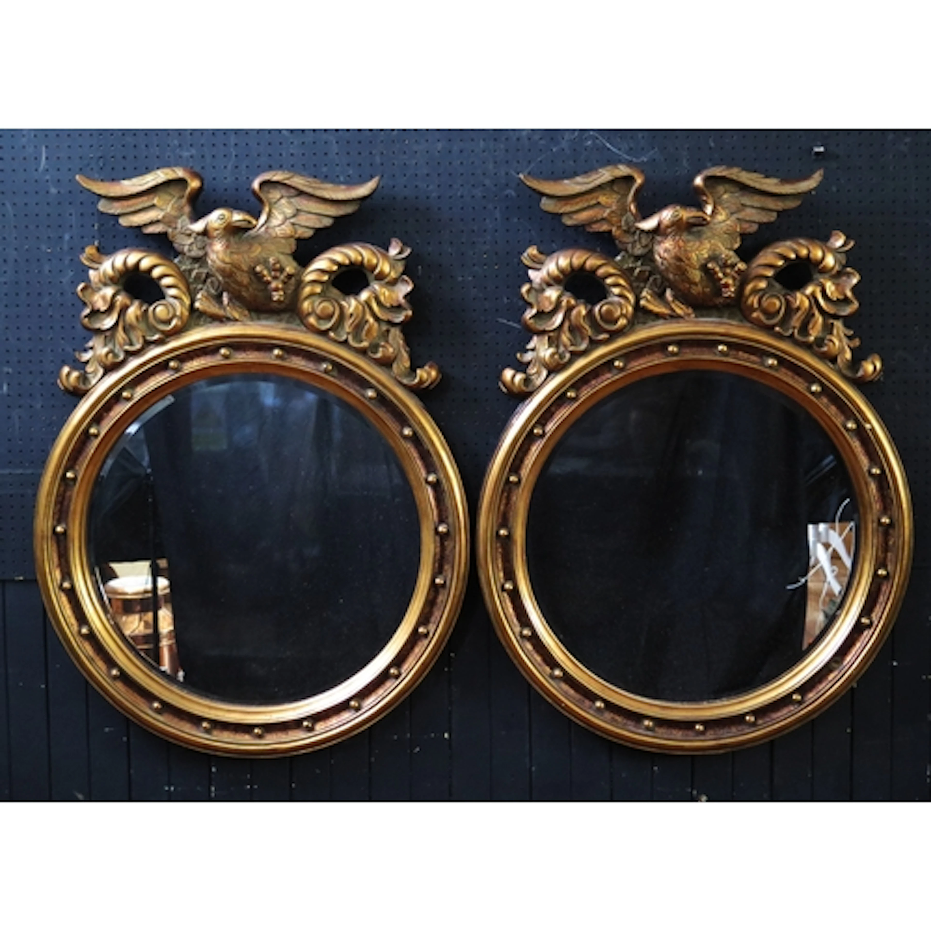 A pair of Regency style circular wall mirrors, with gilded e...