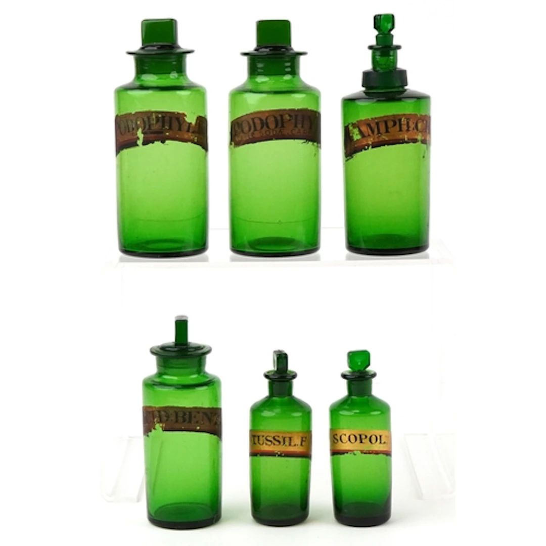 Six antique green glass apothecary bottles with labels inclu...