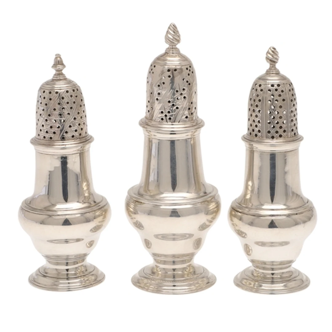 THREE GEORGE III SILVER PEPPER CASTERS. All of similar form,...