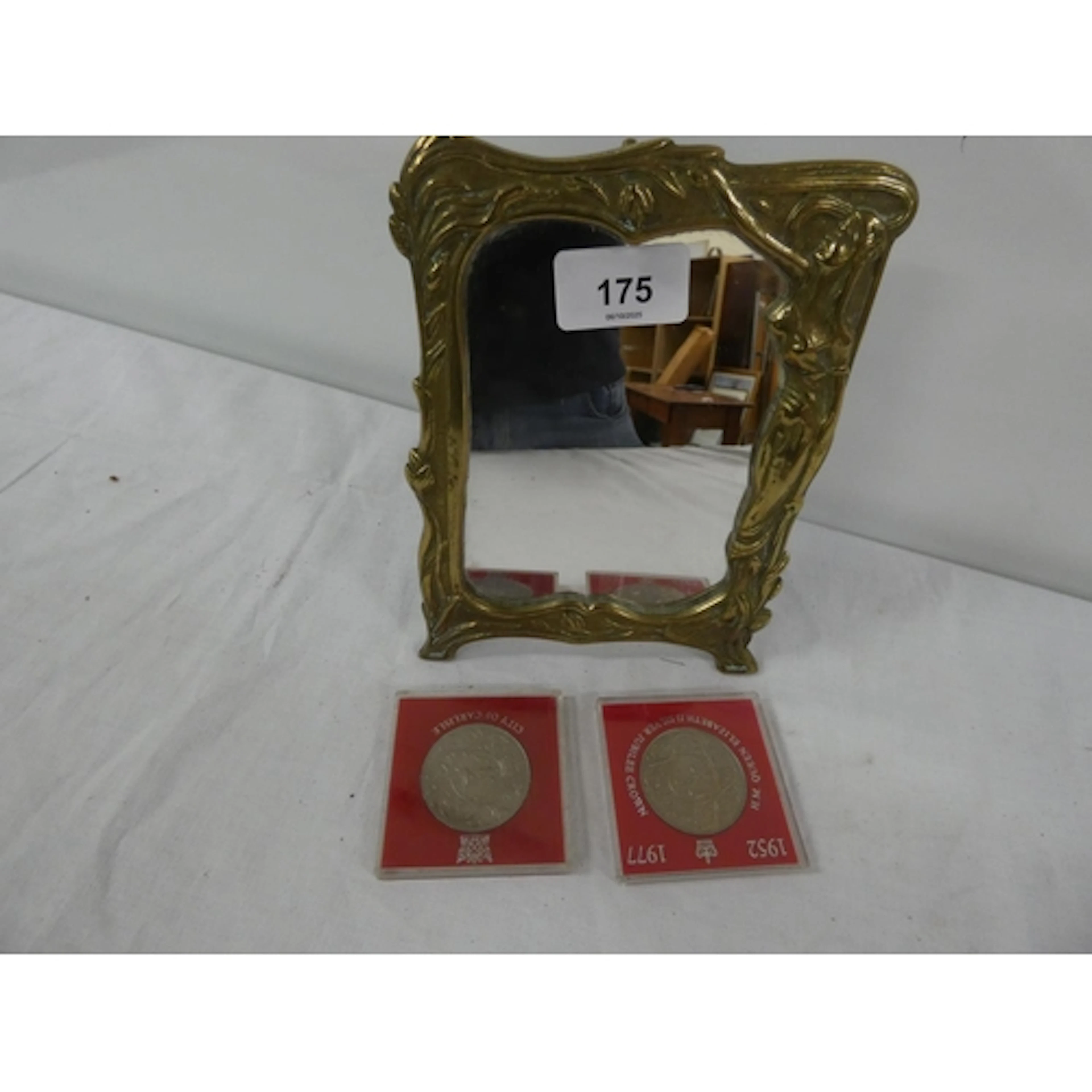 Vintage brass mirror and two commemorative coins.