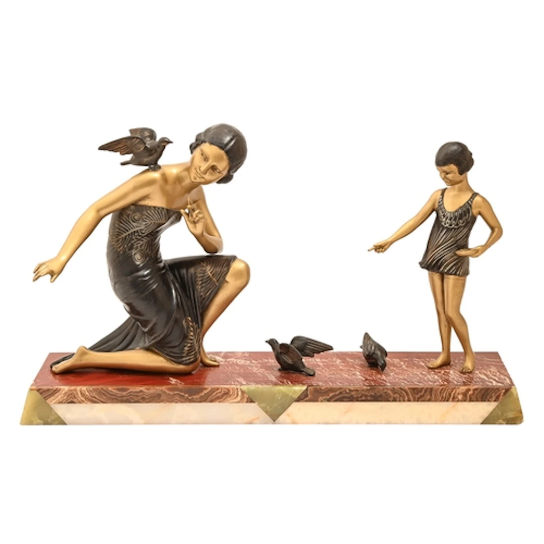 An Art Deco sculpture of a woman and child feeding birds, on...
