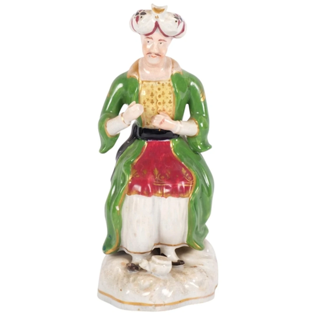 A 19th century Staffordshire figure of a seated Turkish man,...