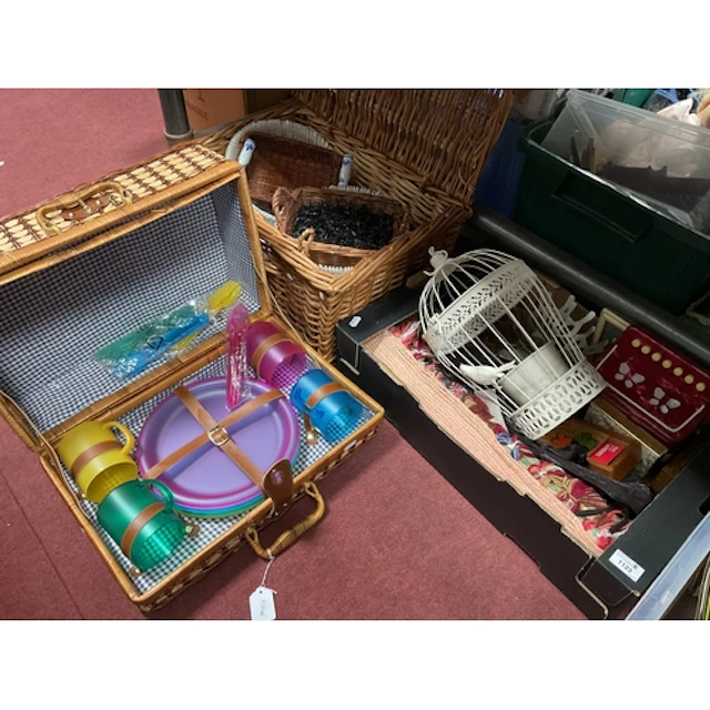 A picnic basket containing plastic plates, mugs and cutlery ...