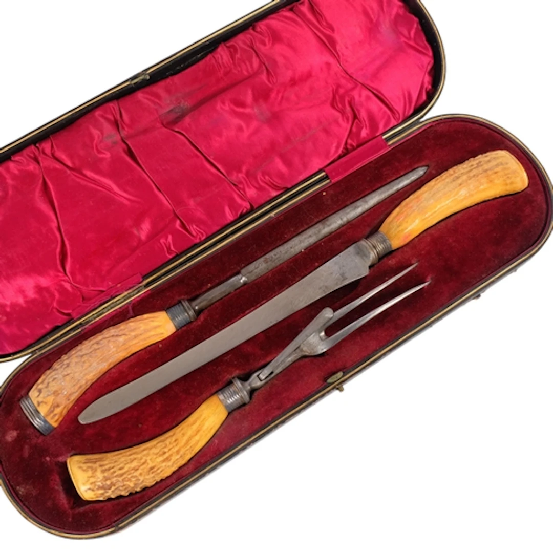 A cased horn-handled carving set, apparently unmarked