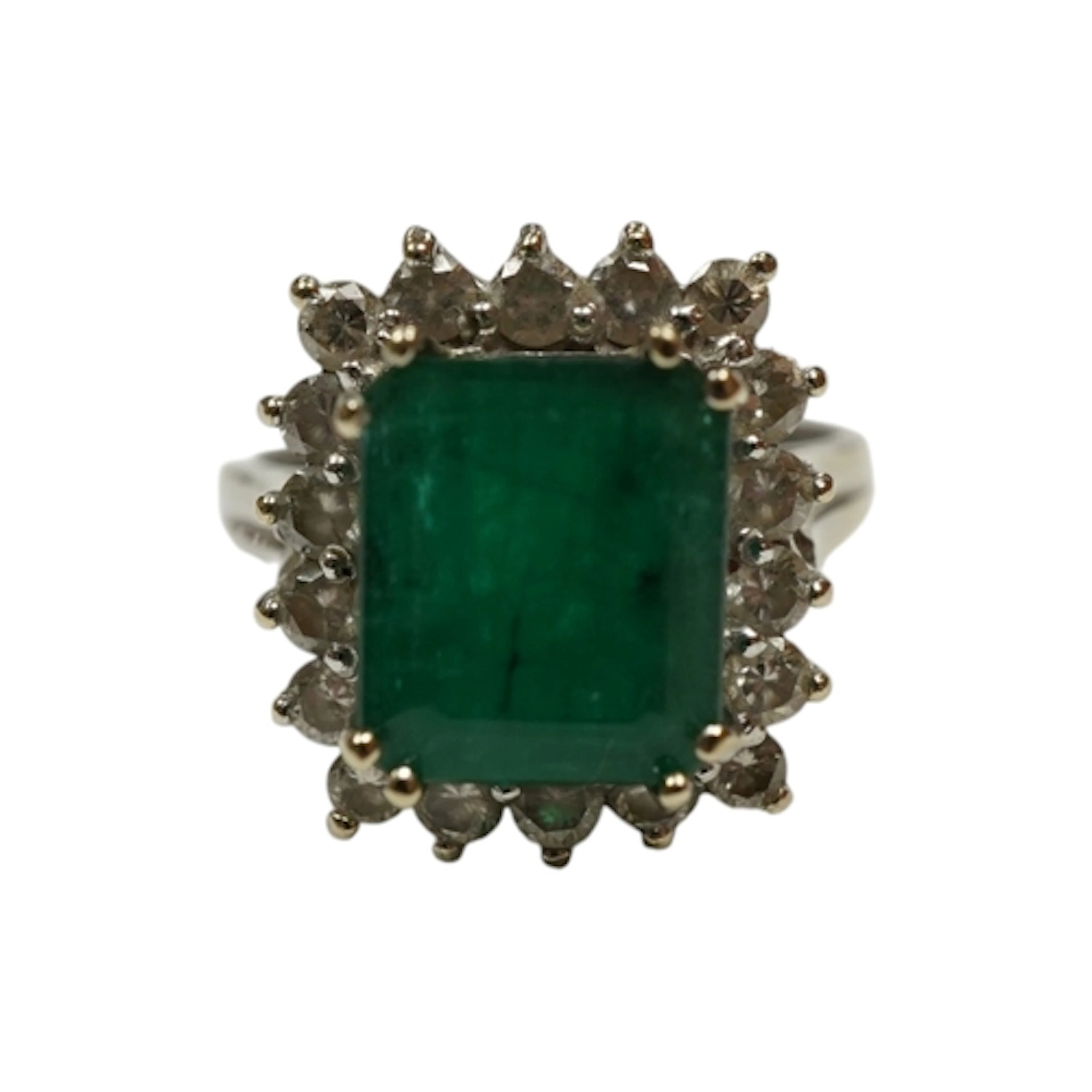 An 18k white metal and single stone emerald rectangular ring...