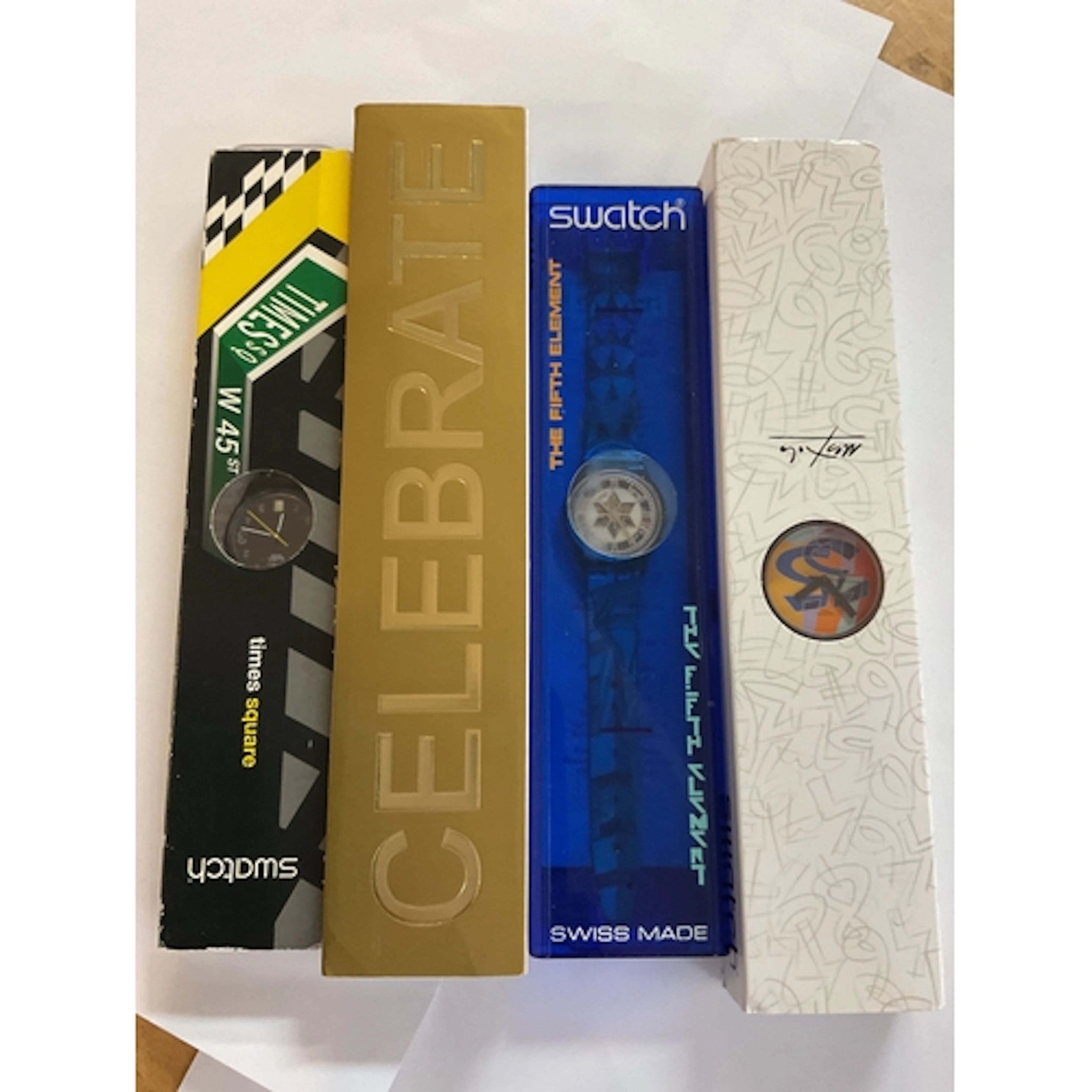 Four cased Swatch Watches.