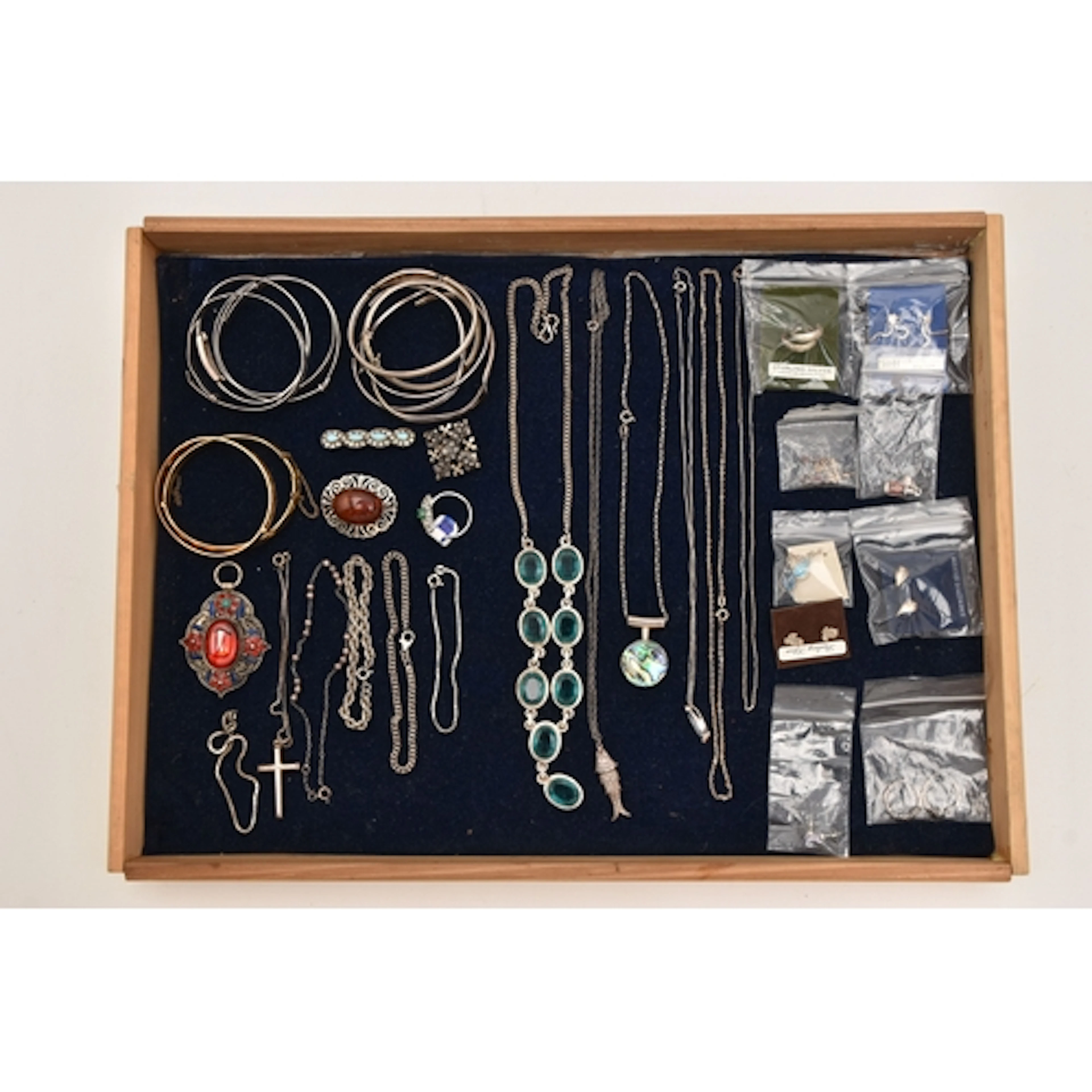 AN ASSORTMENT OF SILVER AND WHITE METAL JEWELLERY, a display...