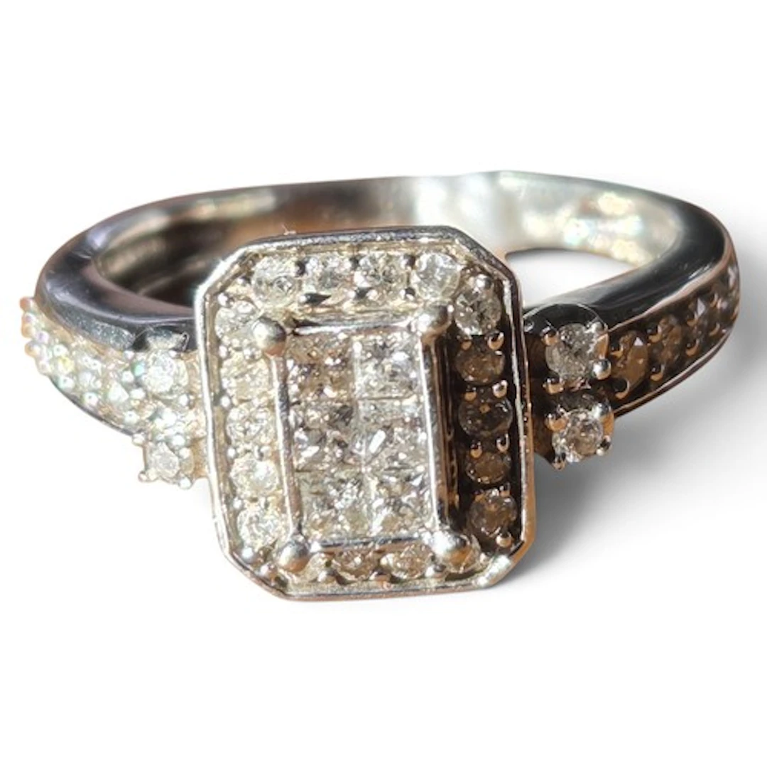 A diamond cluster ring set in 9 carat white gold, the raised...
