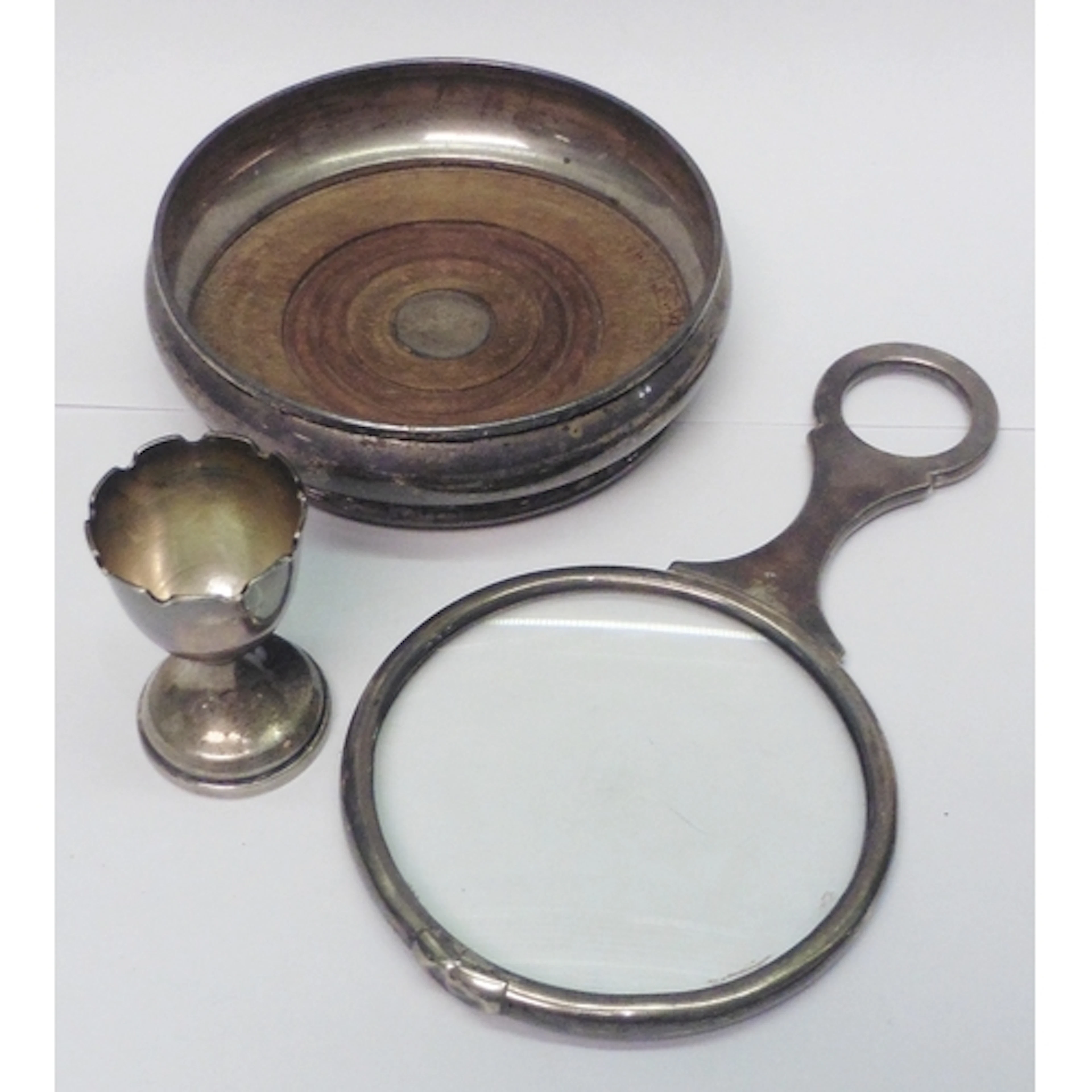 A silver and hardwood coaster, 140mm diameter; a silver egg ...