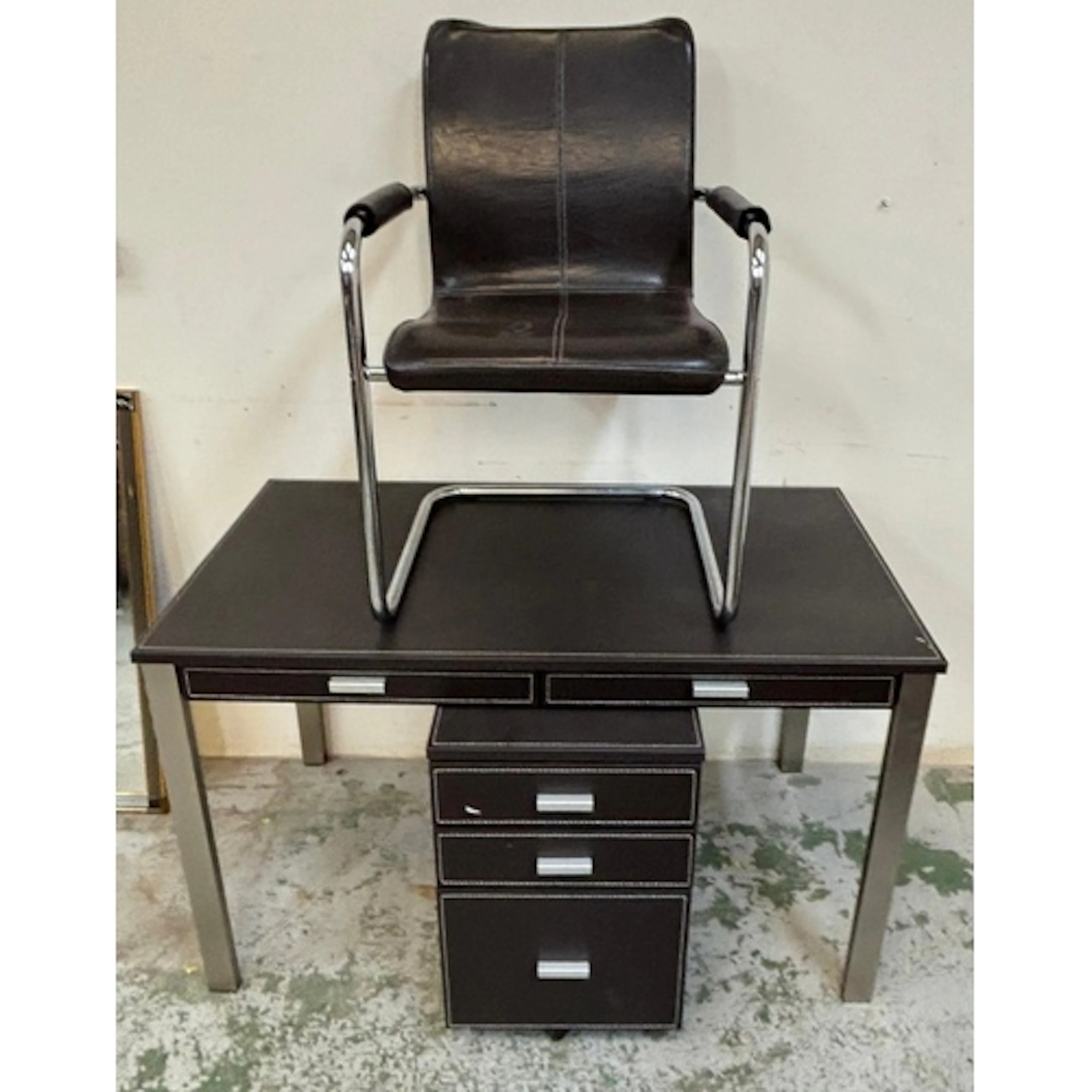A modern office desk with a matching chair. Leather look wit...